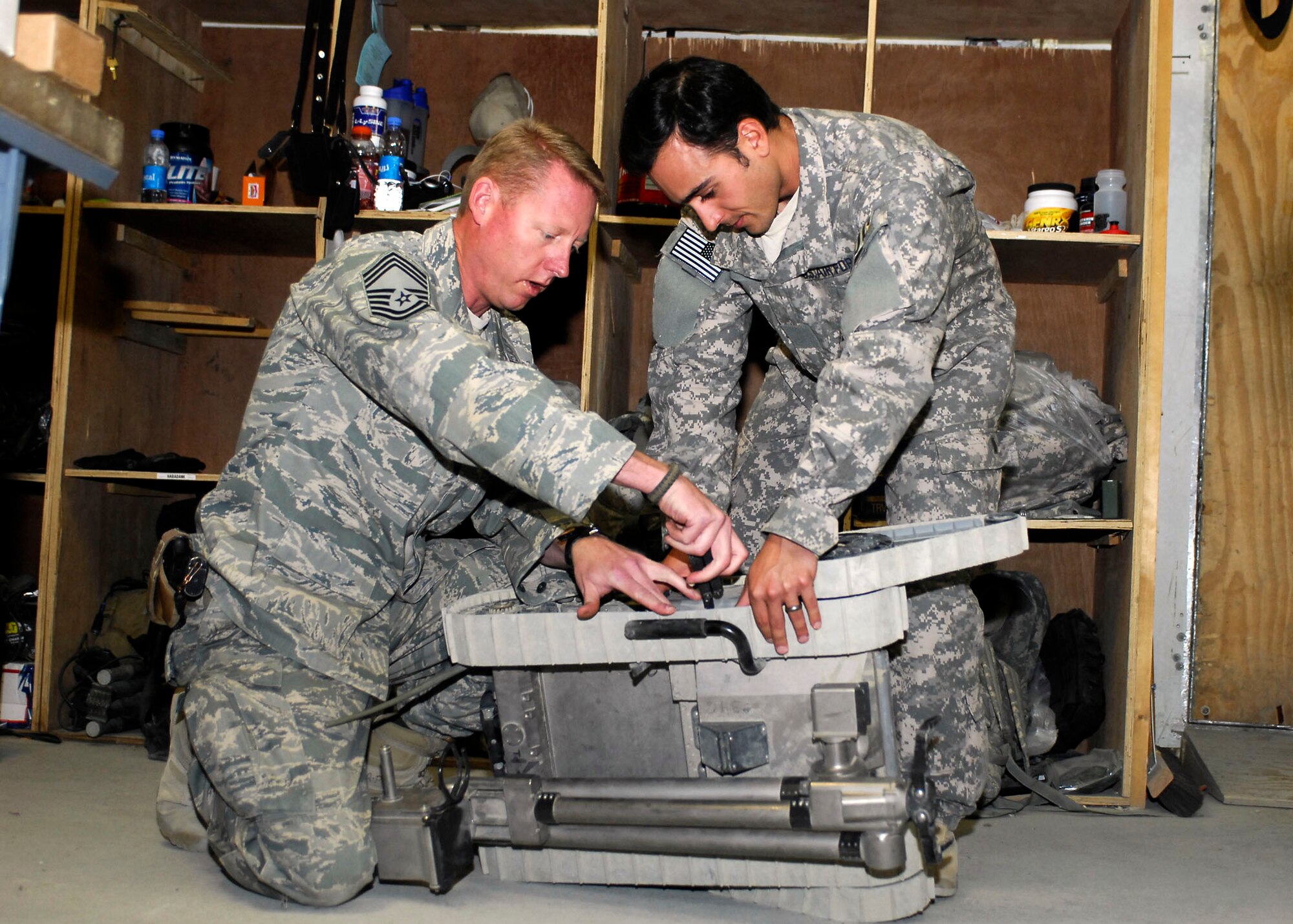 BAGRAM AIRFIELD, Afghanistan -- Chief Master Sgt. Jerry S. Shelton Jr. (left) and Tech. Sgt. Richard Gibbons (right), both Explosive Ordnance Disposal technicians, inspect an EOD bomb removal robot here.  Sergeant Gibbons and his team have disarmed dozens of Improvised Explosive Devices and unexploded ordnance while deployed. His team has gone on dozens of patrols that have helped clear more than 950 miles of roads from explosives.  (U.S. Air Force photo/Senior Airman Felicia Juenke)
