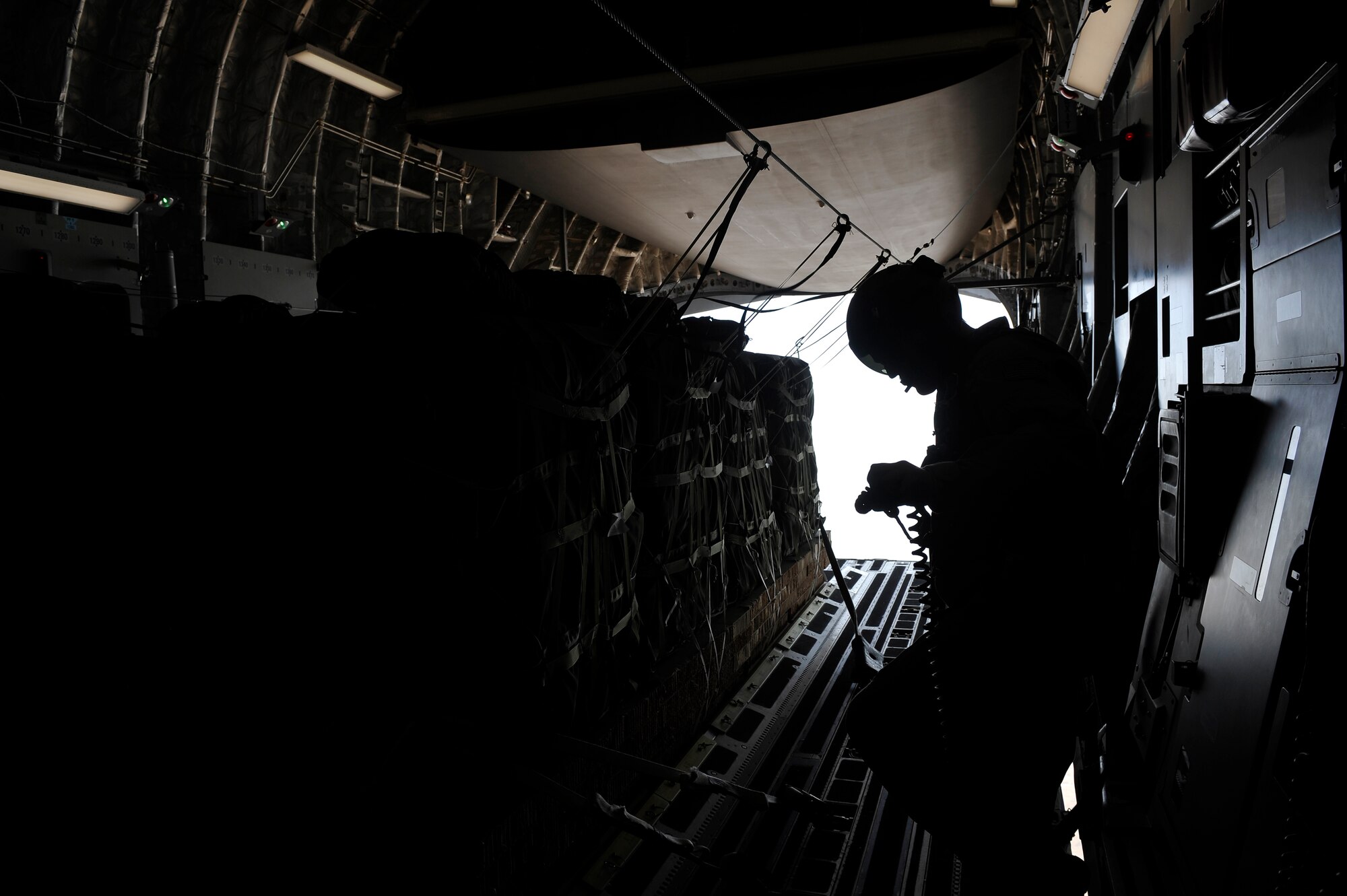 A loadmaster from the 816th Expeditionary Airlift Squadron, deployed to a base in Southwest Asia, waits for the signal to release Container Delivery System bundles from a C-17 Globemaster III Sept. 23, 2009.  The CDS bundles, full of supplies for U.S. Marines, will be dropped to a base in Afghanistan.  (U.S. Air Force photo/Staff Sgt. Angelita Lawrence)