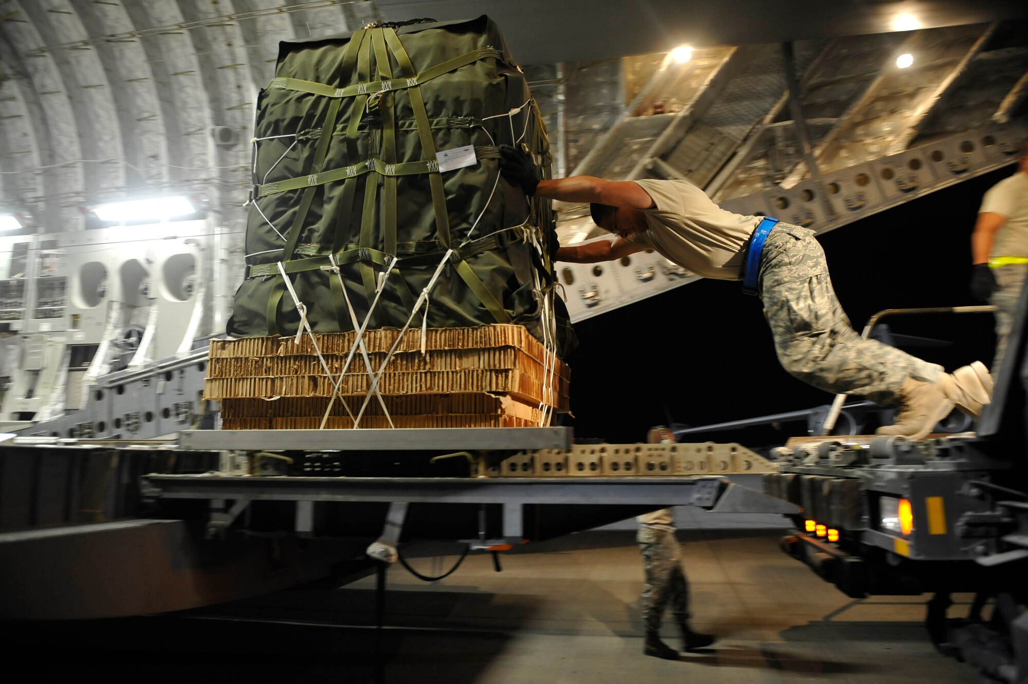 U.S. Air Force Airman 1st Class Andrew Dasilva, 8th Expeditionary Aircraft Maintenance Squadron ramp service specialist, deployed to a base in Southwest Asia, loads a C-17 Globemaster III with Container Delivery System bundles here Sept. 23, 2009.  The CDS bundles, full of supplies for U.S. Marines, will be dropped to a base in Afghanistan.  (U.S. Air Force photo/Staff Sgt. Angelita Lawrence)