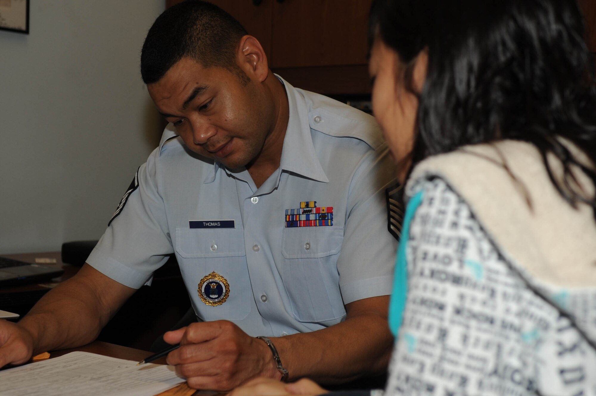 ANDERSEN AIR FORCE BASE, Guam - Master Sgt. Dayne Thomas, Air Force recruiter, helps Krystyn Plain-Cruz, a 2009 Simon Sanchez High School graduate, complete paperwork at the Air Force recruiting office in Agana, Guam, Sept. 22.  (Air Force Photo by Tech. Sgt. Brian Bahret)
