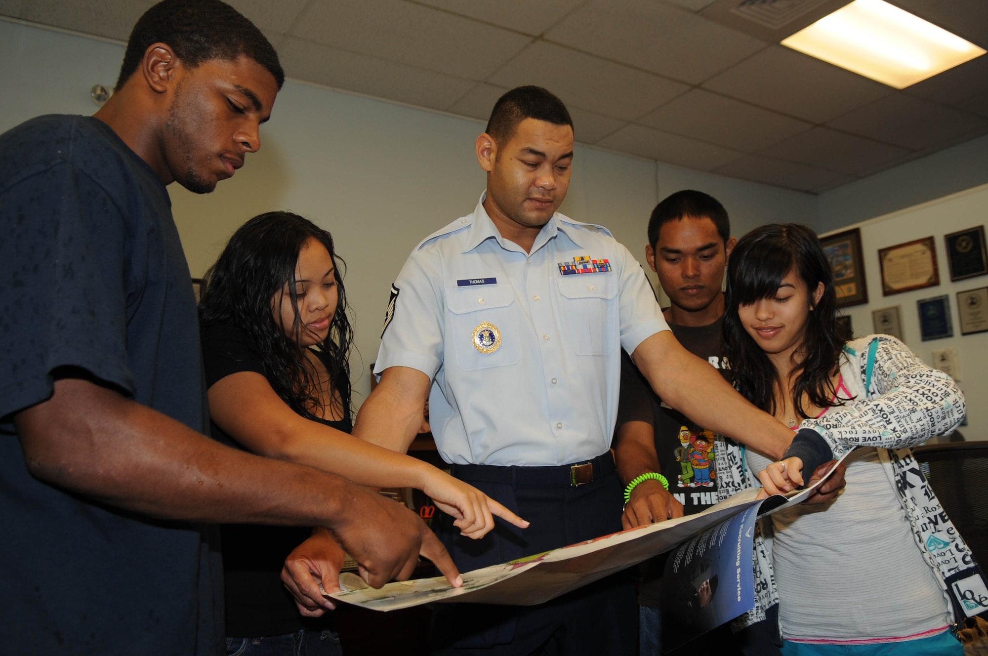 ANDERSEN AIR FORCE BASE, Guam - Devin Johnson, a Guam High School graduate; Melany Faculo, a John F. Kennedy HS graduate; Carl Avelino, a 2002 Simon Sanchez HS graduate; and Krystyn Plain-Cruz, a 2009 Simon Sanchez HS graduate; ask Master Sgt. Dayne Thomas, Air Force recruiter, about the variety of assignments available while attending a meeting at the Air Force recruiting office in Agana, Guam, Sept. 22.  The graduates are enlisting into the Air Force during a ceremony at Andersen's air show Sept. 30.  The Thunderbirds Commander/Leader Lt. Col. Greg Thomas is conducting the ceremony at showcenter in front of the Thunderbird F-16s. (Air Force Photo by Tech. Sgt. Brian Bahret)