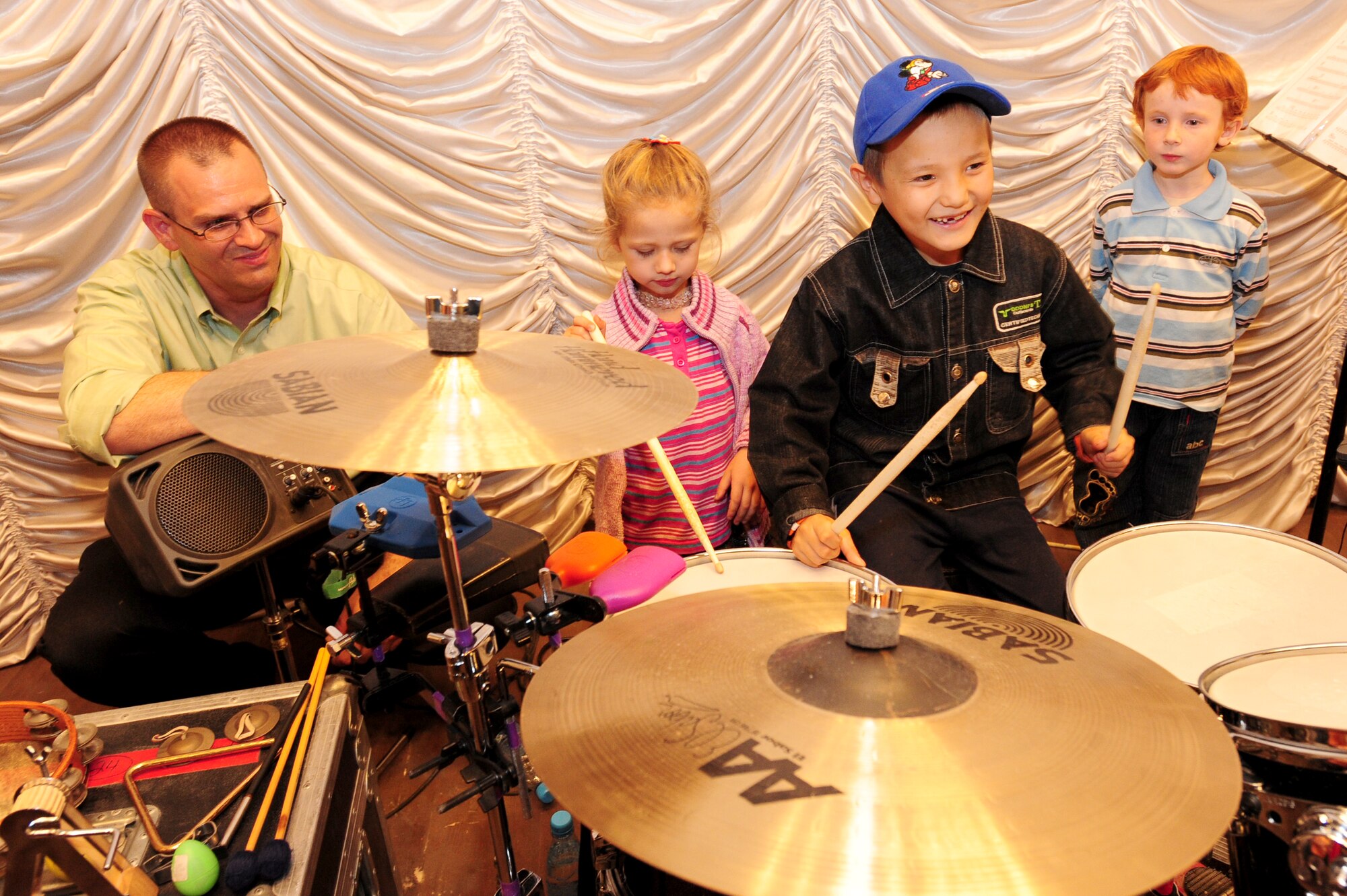 KARABALTA VILLAGE, Kyrgyzstan -- Tech. Sgt. Jim Mangette, U.S. Air Forces Central Command "Falcon" band percussionist, allows local children to enjoy instruments following a performance in Kyrgyzstan. The Falcon band performed a show for the community of Karabalta with the village's mayor in attendance. The band is stationed at a base in Southwest Asia and is deployed from Offutt Air Force Base, Neb. (U.S. Air Force photo/Senior Airman Steele C. G. Britton)