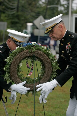 Chief Warrant Officer Nick D'Andrea, special operations officer, and Lt. Gen. Duane D. Thiessen, Deputy Commandant for Programs and Resources carry a wreath to the John Basilone Statue in Raritan, N.J., Sept 27. The celebration of the town's Medal of Honor recipient is the largest military parade in the nation.(Marine Corps photo by Sgt. Randall A. Clinton)