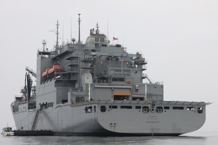 An ordnance Marine straps down cargo as a 7-ton prepares to head out to the flight line during the vertical replenishment operation here Sunday. Out-of-date supplies were replaced with more efficient, safer equipment.