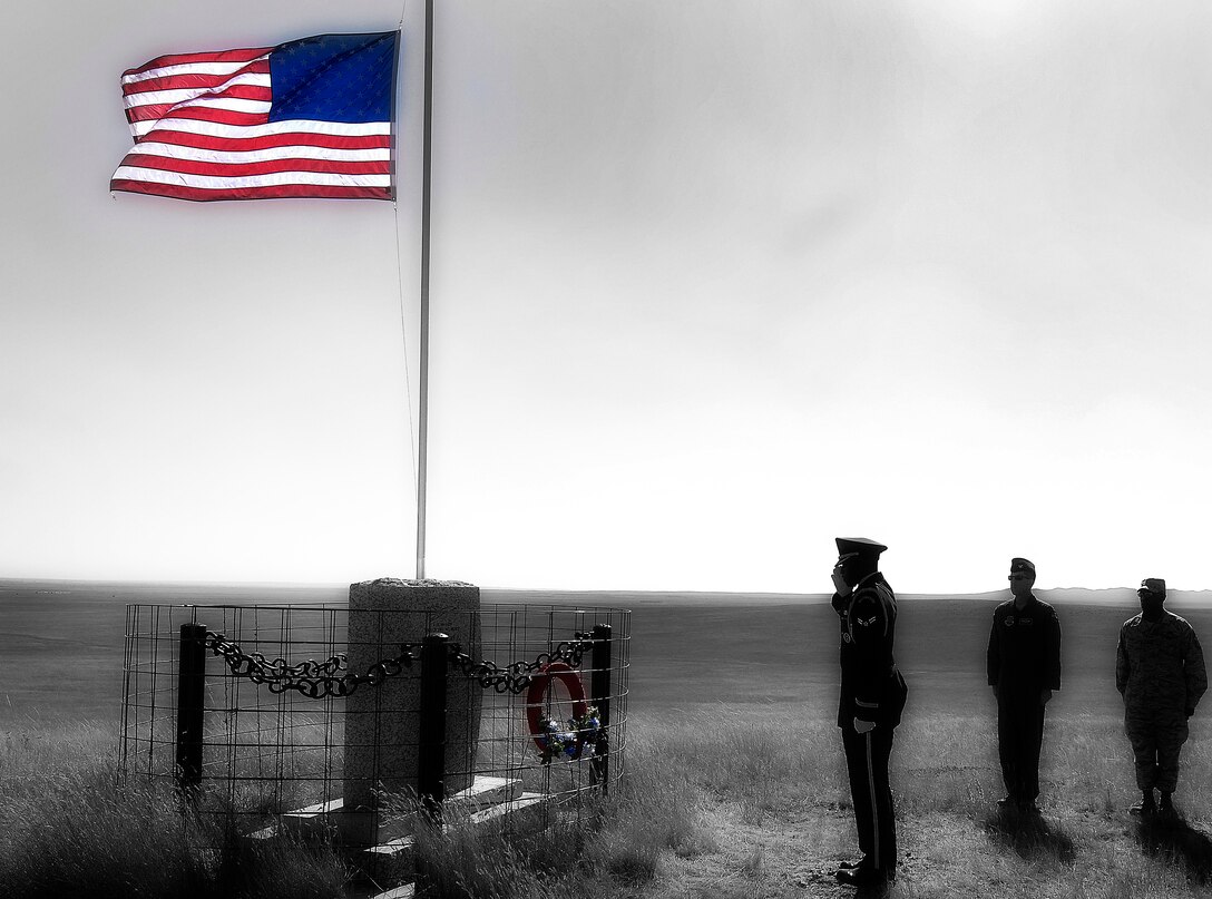 Airman 1st Class Brandon Bussey, 28th Logistics Readiness Squadron traffic management journeyman, salutes the Fury-2 Memorial near Ekalaka, Mont., Sept. 26. The memorial is in remembrance of four Airmen who lost their lives when a B-1 crashed 12 years ago. (U.S. Air Force photo illustration/Airman 1st Class Joshua J. Seybert)