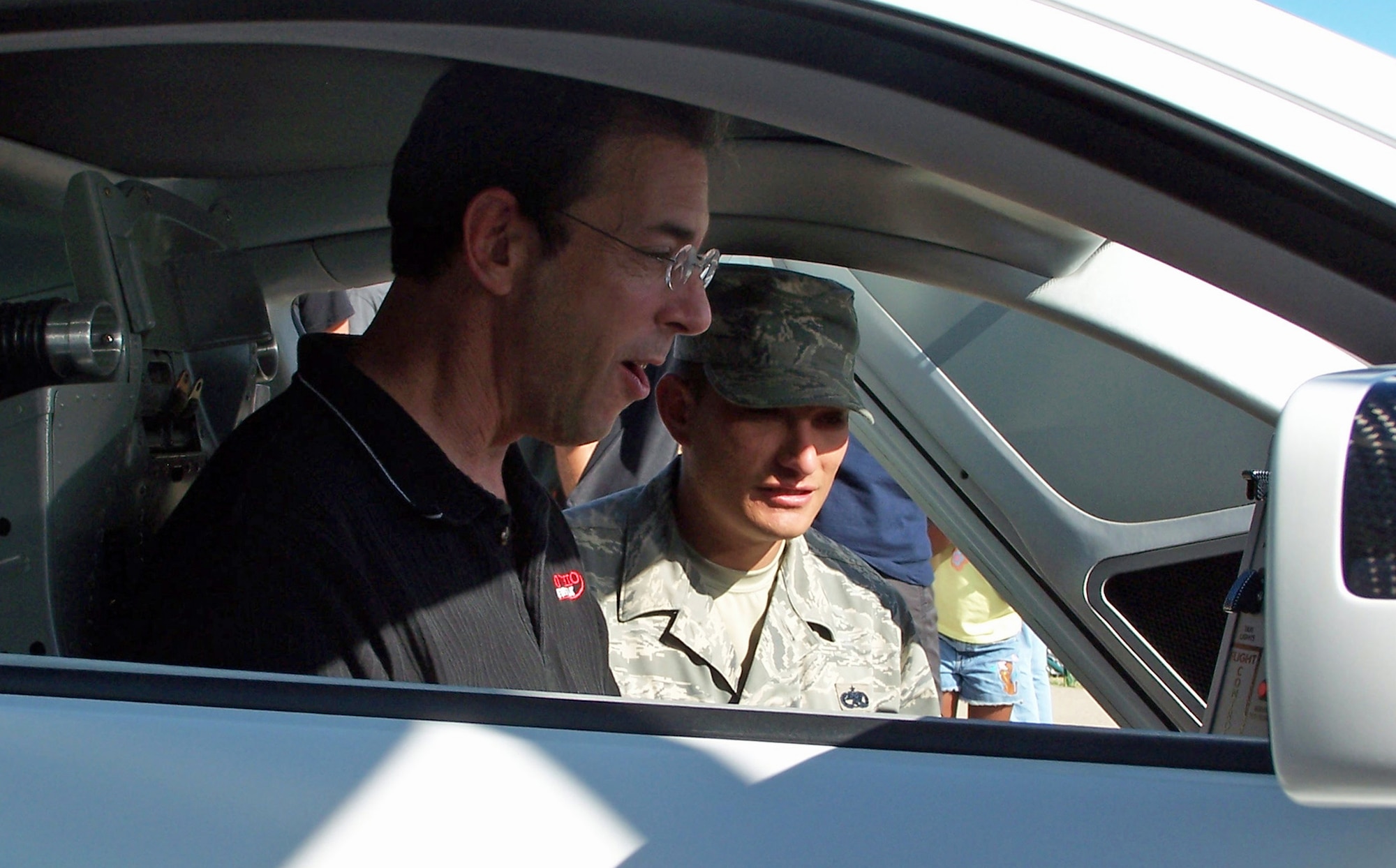 Staff Sgt. Chad Tanner gives syndicated radio personality and consumer advocate Clark Howard a tour of the Air Force 'X-1' Mustang, Sept. 18, 2009 at Wright State University.  The X-1 is a modified Ford Mustang with a jet cockpit that includes a single-driver ejection seat in the center of the vehicle, short shifter, flight stick and advanced instrumentation panel. The car was in town to support recruiting efforts during the U.S. Air Force Marathon.  Howard ran the marathon's 5K race and met with Airmen and their families, answering questions about personal finance and today's economy. Tanner is with the 338th Recruiting Squadron at Wright-Patterson Air Force Base. (Air Force photo/Ted Theopolos)