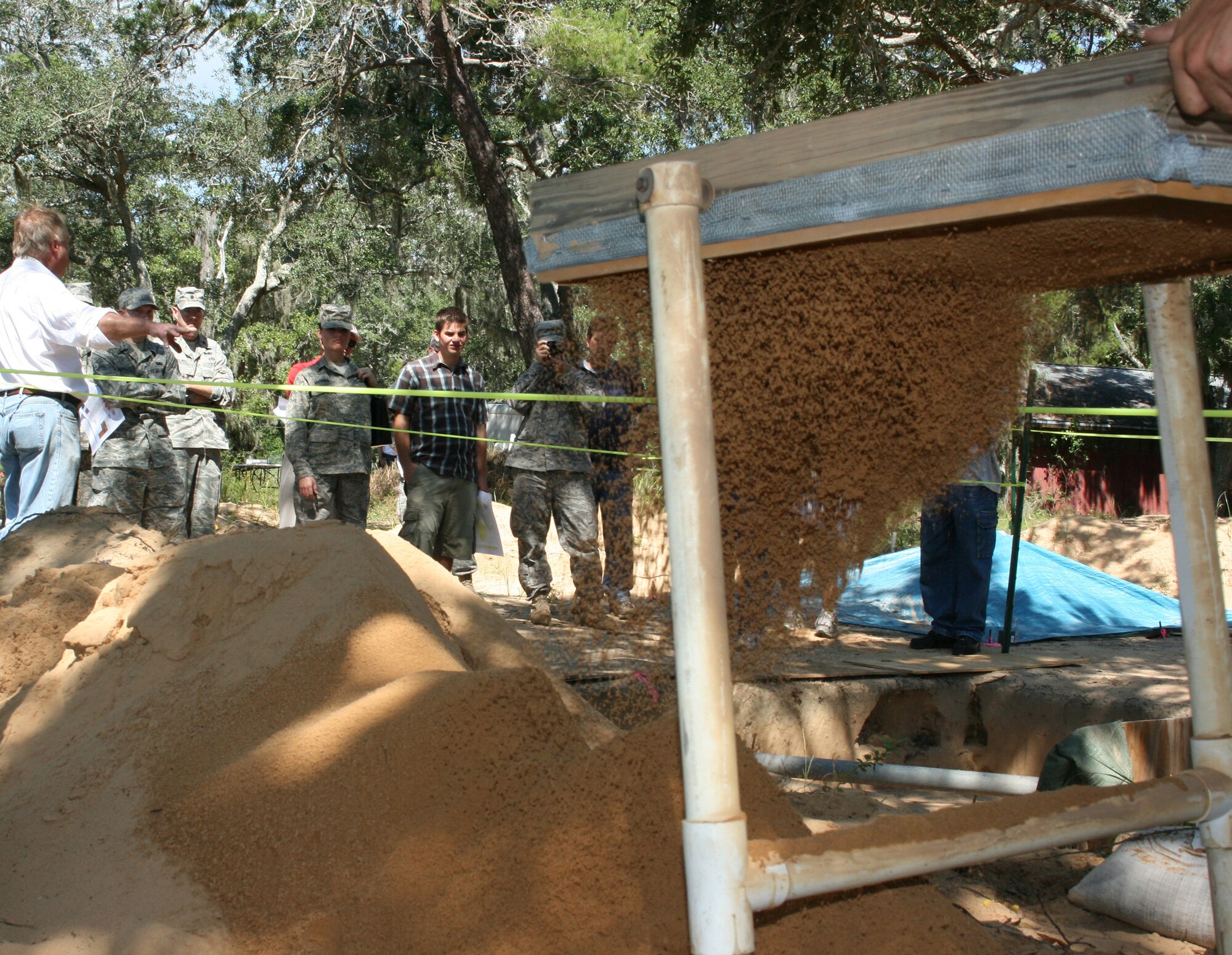 Airmen and community members watch as sand is sifted looking for ancient artifacts during a tour of an archeological site on the Eglin reservation Sept. 25. They toured seldom seen parts of Eglin to learn more about the base. A scientific team from the Air Force's cultural resource branch excavates ancient artifacts and pottery in an effort to preserve archeological items found on the reservation. (U.S. Air Force photo/ 2nd Lt. Andrew Caulk.)