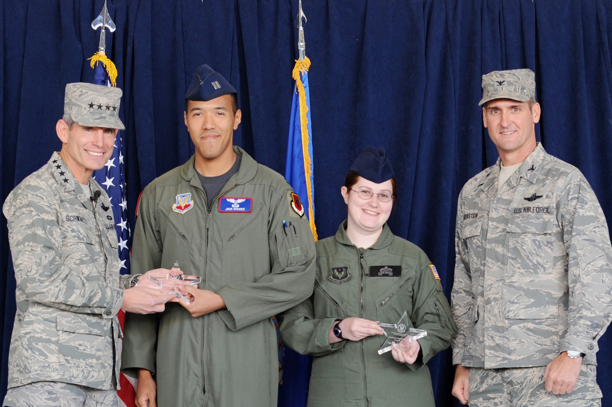 Air Force Chief of Staff Gen. Norton Schwartz and Col. Peter Gersten give a special presentation to Capt. Jack Rhodes and Tech. Sgt. Alyson Hathaway as top graduates during the initial qualification training graduation at Creech Air Force Base, Nev., Sept. 25, 2009.  General Schwartz attended the ceremony as the presiding officer for the first UAS graduation. Colonel Gersten is the 432nd Wing commander. (U.S. Air Force photo/Airman 1st Class Brett Clashman)