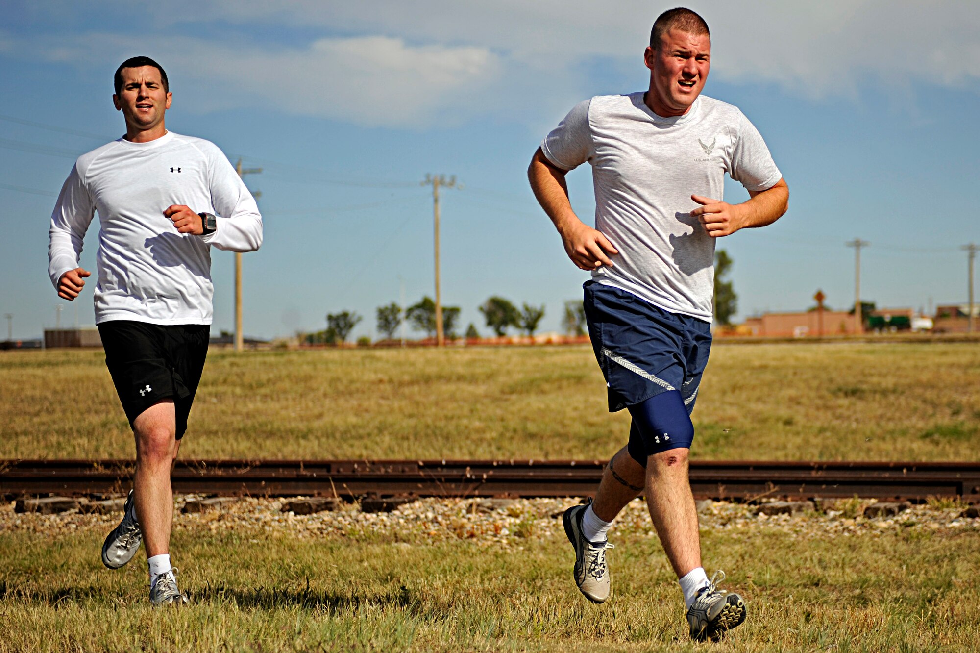 (Right) Airman 1st Class Steven Scalle, 28th Security Forces Squadron patrolman, and Staff Sgt. Patrick McMahon, 28 SFS patrolman, run during the Raider Challenge here, Sept. 25. The race featured eight different checkpoints throughout the base including Camp Lancer, the PRIDE hangar and Gateway Lake. (U.S. Air Force photo/Airman 1st Class Matthew Flynn)