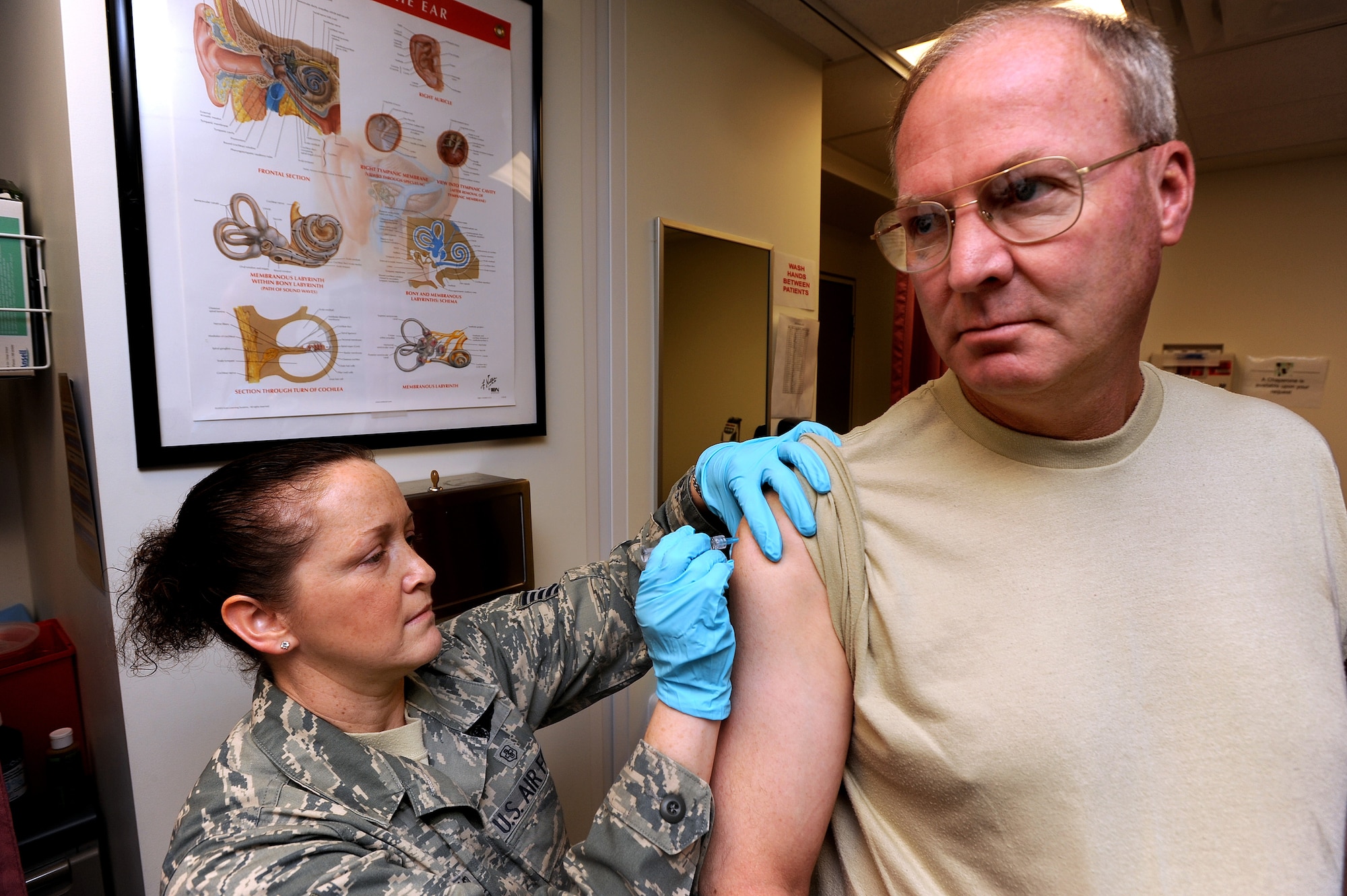 Air Force Gen. Craig R. McKinley, chief, National Guard Bureau, receives his seasonal flu shot from Tech Sgt. Angela Archer at The Pentagon, Friday, Sept.
25, 2009. "Protect yourself, your family, & your coworkers and get yours soon," he said, after receiving it.  
