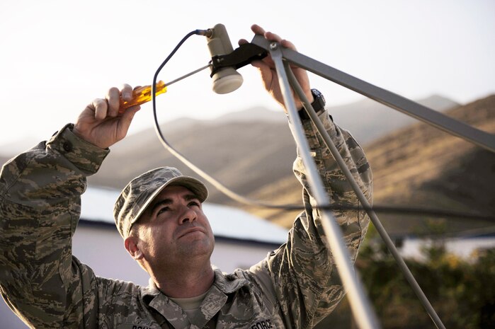 Master Sgt. Ira Doubet adjusts the Armed Forces Network antenna in preparation for the start of a football game Sept. 11, 2009, near Panjshir, Afghanistan. Sergeant Doubet is the NCO in charge of the command post at the provincial reconstruction team here. He's a Cambridge Springs, Penn., native deployed from Schriever Air Force Base, Colo. (U.S. Air Force photo/Staff Sgt. J.G. Buzanowski)