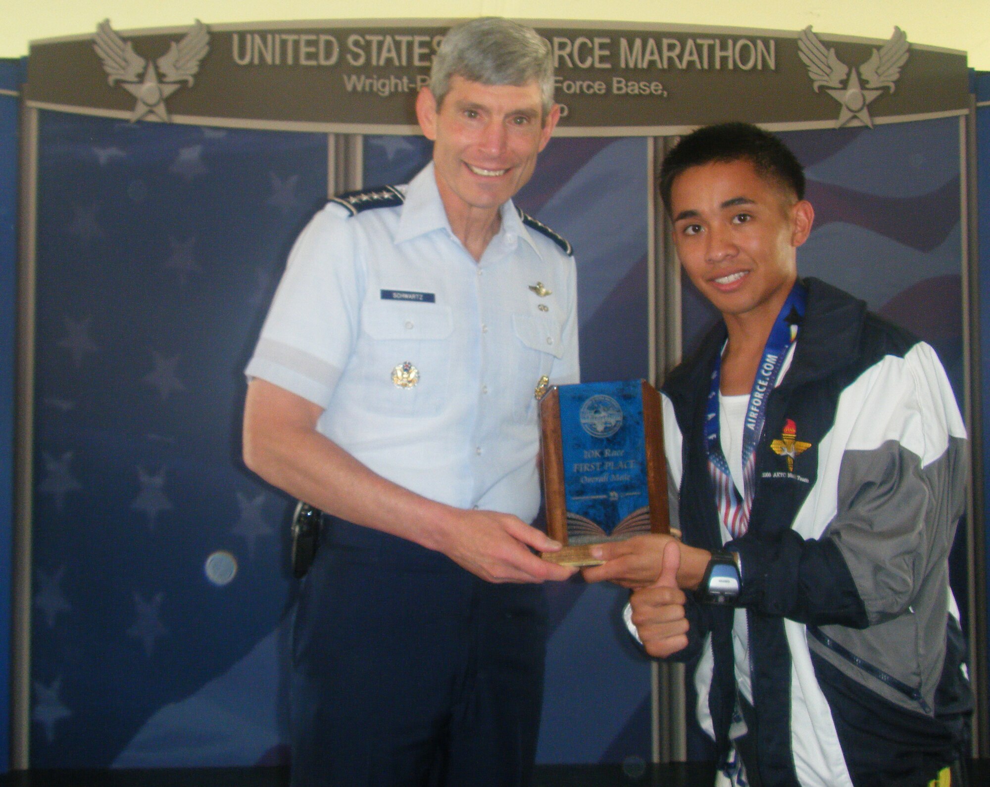 Chief of Staff of the Air Force Norton A. Schwartz awarded Senior Airman Kristoffer Chacon, 325th Force Support Squadron Food Specialist with a trophy for his first place win in the Air Force Marathon 10K, Sept 19 at Wright-Patterson Air Force Base. (Courtesy photo)