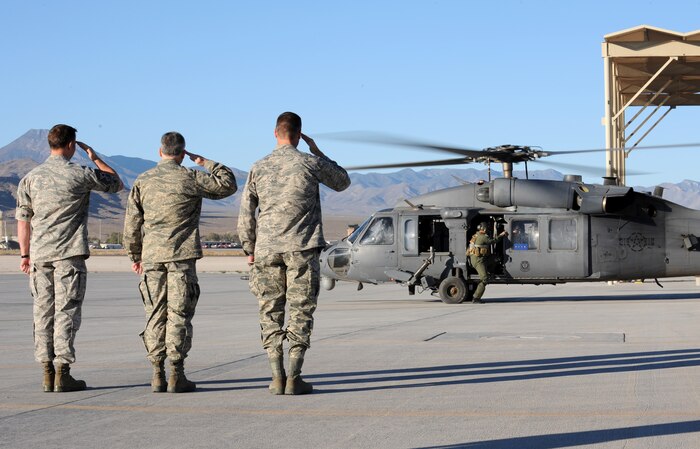 CREECH AIR FORCE BASE, Nev. -- (left to right) Chief Master Sgt. Richard Cromer, 432d Wing command chief, Col. Gregory Christ, 432nd Wing vice commander and Col. Peter Gersten, 432nd Wing commander render a salute as an Air Force HH-60 Pave Hawk arrives from Nellis Air Force Base, Nev., transporting Gen. Norton A. Schwartz, Chief of Staff of the United States Air Force, Sept. 25.  Schwartz flew into Creech AFB, to  preside over the first UAS graduation. (U.S. Air Force photo by Airman 1st Class Brett Clashman) 