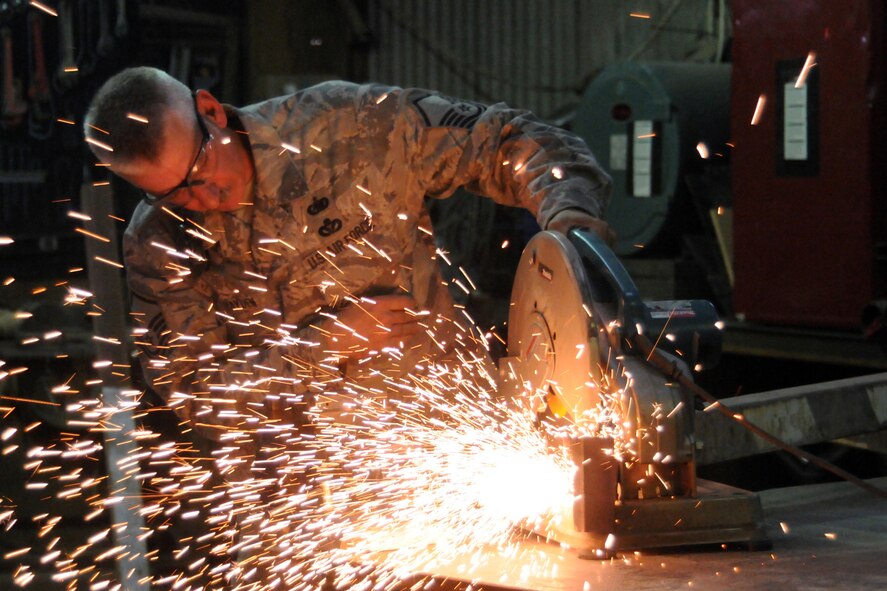 KIRKUK AIR BASE, Iraq - Master Sgt. Carl Hayden, 506th Expeditionary Civil Engineer Squadron, cuts steal support beams using a table saw Sept. 20. The support beams where being used to build a covered vehicle staging area. Sergeant Hayden, a Reservist from Renton, Wash., is deployed from the 446th Civil Engineer Squadron, McChord Air Force Base, Wash. (U.S. Air Force photo/Staff Sgt. Joshua Breckon)