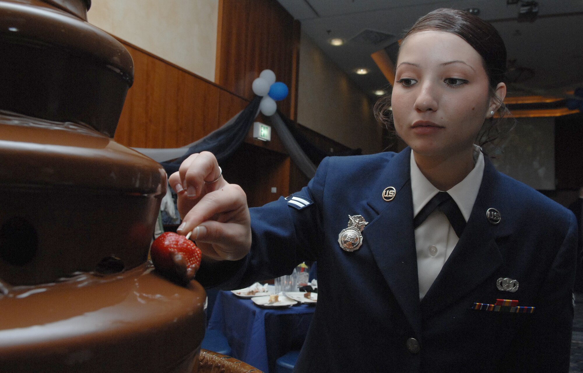 SPANGDAHLEM AIR BASE Germany -- Airman 1st Class Kimura Helwig, 52nd Security Forces Squadron, dips a strawberry in the chocolate fountain at the 2009 Air Force Ball here at Club Eifel Sept. 25. Sabers from across the 52nd Fighter Wing were invited to attend the event, which observed the Air Force's birthday and Airmen's contributions around the globe.  This year's theme was "All in...Globally Engaged" to recognize the unique role the Air Force fulfills in missions across the world. (U.S. Air Force photo/Airman 1st Class Nick Wilson)