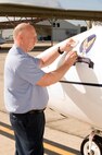 Jim Seagraves, a sign painter assigned to the 12th Flying Training Wing Maintenance Directorate at Randolph Air Force Base, Texas, puts the "Spirit of Pensacola" nose art on the 479th Flying Training Group flagship T-1A Jayhawk Sept. 28. The aircraft will eventually be used to train combat systems officers at Naval Air Station Pensacola, Fla., when the 479th FTG begins operations there following an Oct. 2 activation. (U.S. Air Force photo by Steve Thurow)