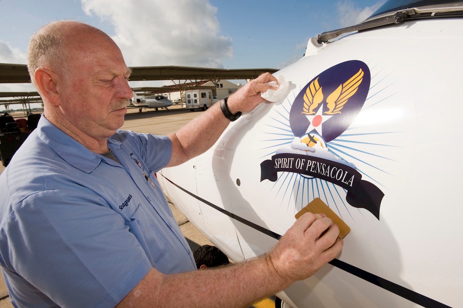 Jim Seagraves, a sign painter assigned to the 12th Flying Training Wing Maintenance Directorate at Randolph Air Force Base, Texas, puts the "Spirit of Pensacola" nose art on the 479th Flying Training Group flagship T-1A Jayhawk Sept. 28. The aircraft will eventually be used to train combat systems officers at Naval Air Station Pensacola, Fla., when the 479th FTG begins operations there following an Oct. 2 activation. (U.S. Air Force photo by Steve Thurow)