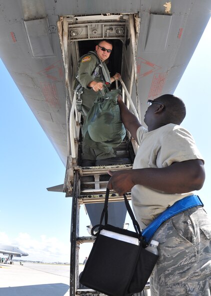 EGLIN AIR FORCE BASE, Fla. -- Staff Sgt. Jerome Smith, hands Maj. Scott Hall, 337th Test and Evaluation Squadron, gear for a test mission Sept. 24, here. Two B-1B Lancers were brought from Dyess Air Force Base, Texas, for test missions last week in an effort to better defend the aircraft for today’s warfighters and prove the strength of new software. The B-1 is a long range, multi-role, heavy bomber with a wingspan of 137 feet, and is capable of intercontinental flight unrefueled. (U.S. Air Force photo/ Sam King)