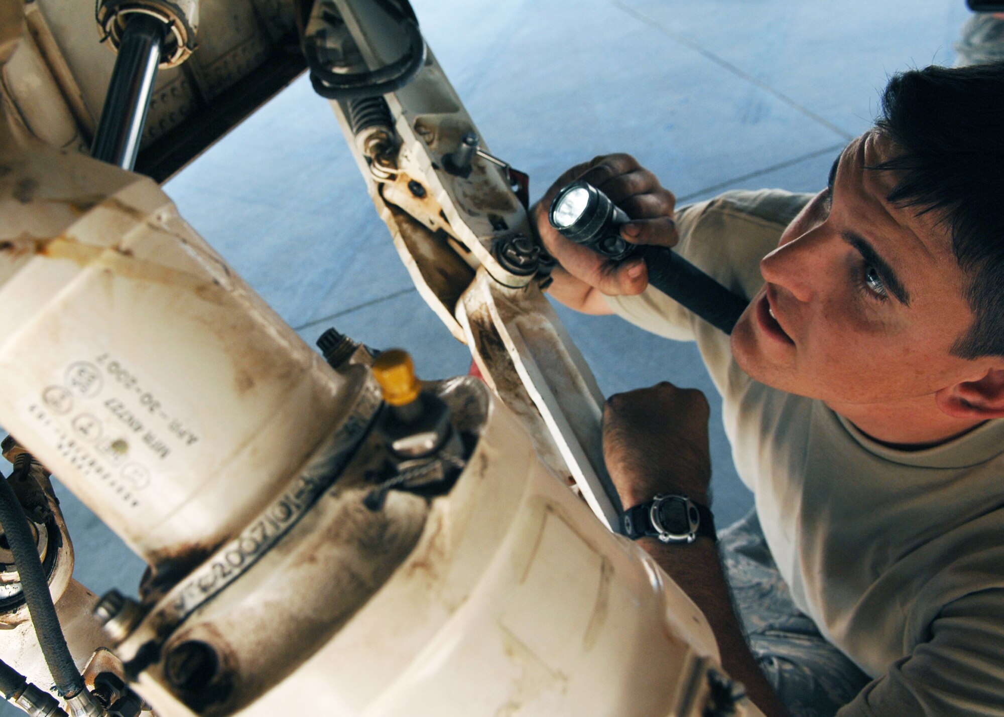 JOINT BASE BALAD, Iraq -- Airman Adam Osgood, 332nd Expeditionary Aircraft Maintenance Squadron crew chief, scans the underside of an F-16 Fighting Falcon while performing a routine inspection here Sept. 24. The 332nd EAMXS is responsible for aircraft launch and recovery, daily maintenance, and refueling. Airman Osgood is deployed from Spangdahlem Air Base, Germany. (U.S. Air Force photo/Senior Airman Christopher Hubenthal)
