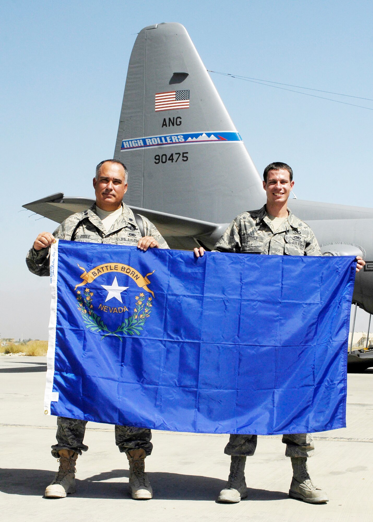 Lt. Col. Barltey O'Toole (left) and his son Senior Airman Bartley O'Toole hold the Nevada state flag Sept. 24, 2009, at Bagram Airfield, Afghanistan. Colonel O'Toole is the 774th Expeditionary Airlift Squadron director of operations and Airman O'Toole is a 774th EAS aircrew flight equipment journeyman. (U.S. Air Force photo/Senior Airman Felicia Juenke)