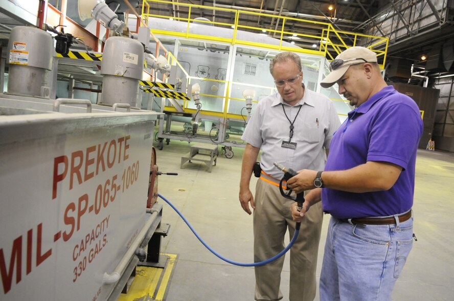 James Cranford and Todd Lavender look over a Prekote surface pretreatment vat. The treatment is less hazardous than previous methods. U. S. Air Force file photo by Sue Sapp