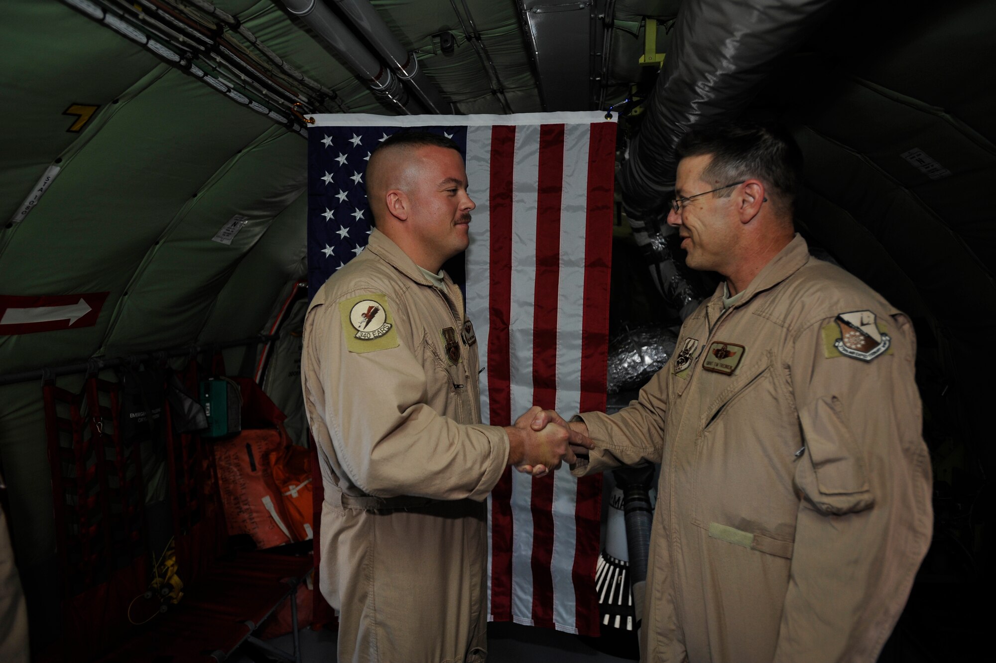 U.S. Air Force Master Sgt. Nathan Neidhardt, 340th Expeditionary Air Refueling Squadron boom operator, deployed to a base in Southwest Asia shakes hands with Chief Master Sgt. Timothy Treinen, 340th Expeditionary Air Refueling Squadron  chief boom operator, after being promoted to master sergeant here Sept. 25.  Sergeant Neidhardt is being pinned on while in mid-flight over Afghanistan aboard his KC-135 Stratotanker. (US Air Force photo by Staff Sgt. Angelita Lawrence)(released)
