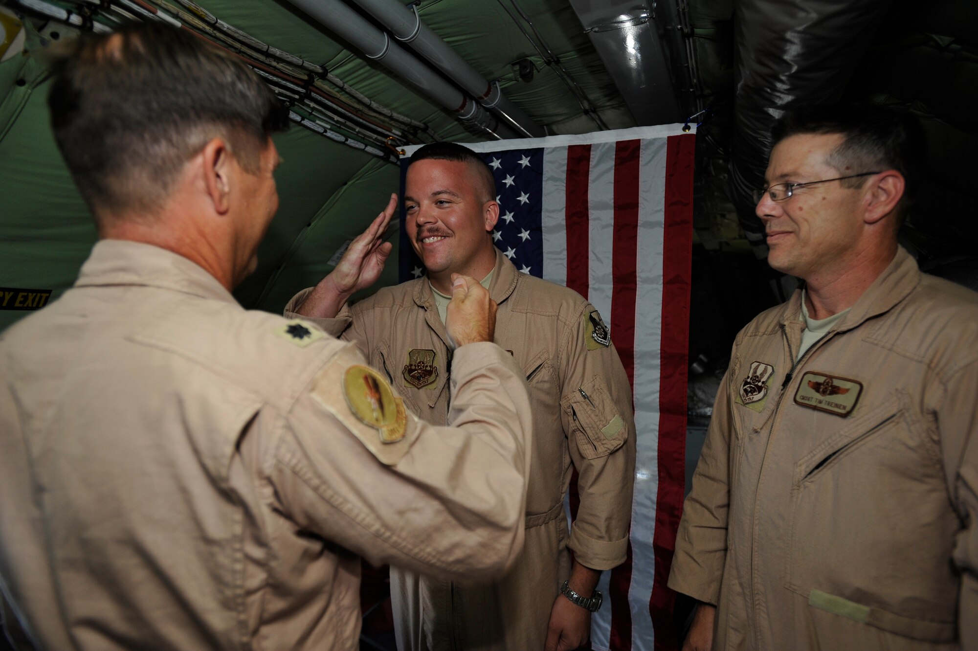 U.S. Air Force Master Sgt. Nathan Neidhardt, 340th Expeditionary Air Refueling Squadron boom operator, deployed to a base in Southwest Asia, salutes after being promoted to Master Sergeant by Lt. Col Kenneth Fogler, 340th Expeditionary Air Refueling Squadron pilot, here Sept. 25.  Sergeant Neidhardt was promoted while in mid-flight over Afghanistan aboard his KC-135 Stratotanker. (US Air Force photo by Staff Sgt. Angelita Lawrence)(released)
