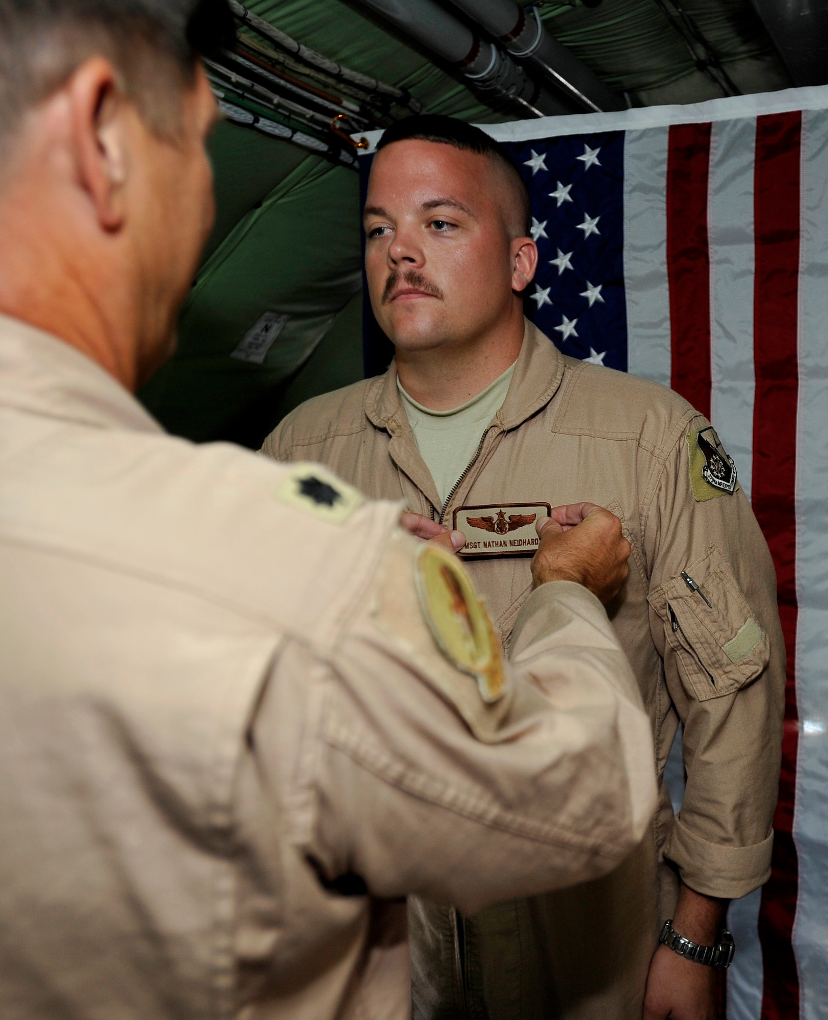 U.S. Air Force Master Sgt. Nathan Neidhardt, 340th Expeditionary Air Refueling Squadron boom operator, deployed to a base in Southwest Asia has his new rank pinned on  by Lt. Col. Kenneth Fogler, 340th Expeditionary Air Refueling Squadron pilot, here Sept. 25.  Sergeant Neidhardt was promoted  on board his KC-135 Stratotanker while in mid-flight over Afghanistan. (US Air Force photo by Staff Sgt. Angelita Lawrence)(released)