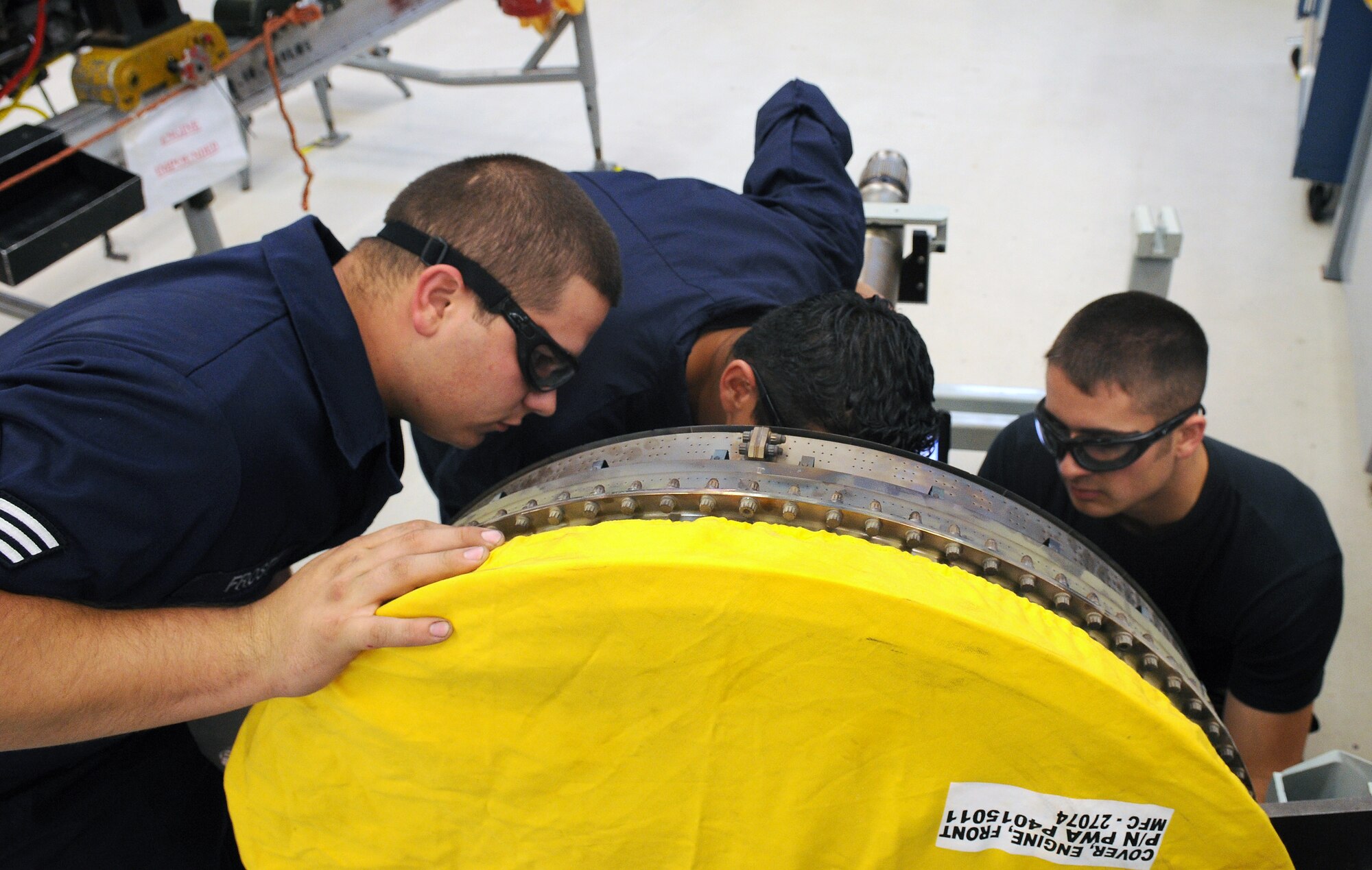 SPANGDAHLEM AIR BASE, Germany -- Senior Airman David Frost, Staff Sgt. Sergio Mejia and Airman 1st Class Christian Davey, 52nd Component Maintenance Squadron aerospace propulsion journeymen, inspect parts on an engine to prepare it for re-installation at the propulsion flight maintenance shop Sept. 24. The 52nd CMS Propulsion Flight repairs and ships an average of eight to 10 engines to Afghanistan every month. (U.S. Air Force photo/Airman 1st Nathanael Callon)