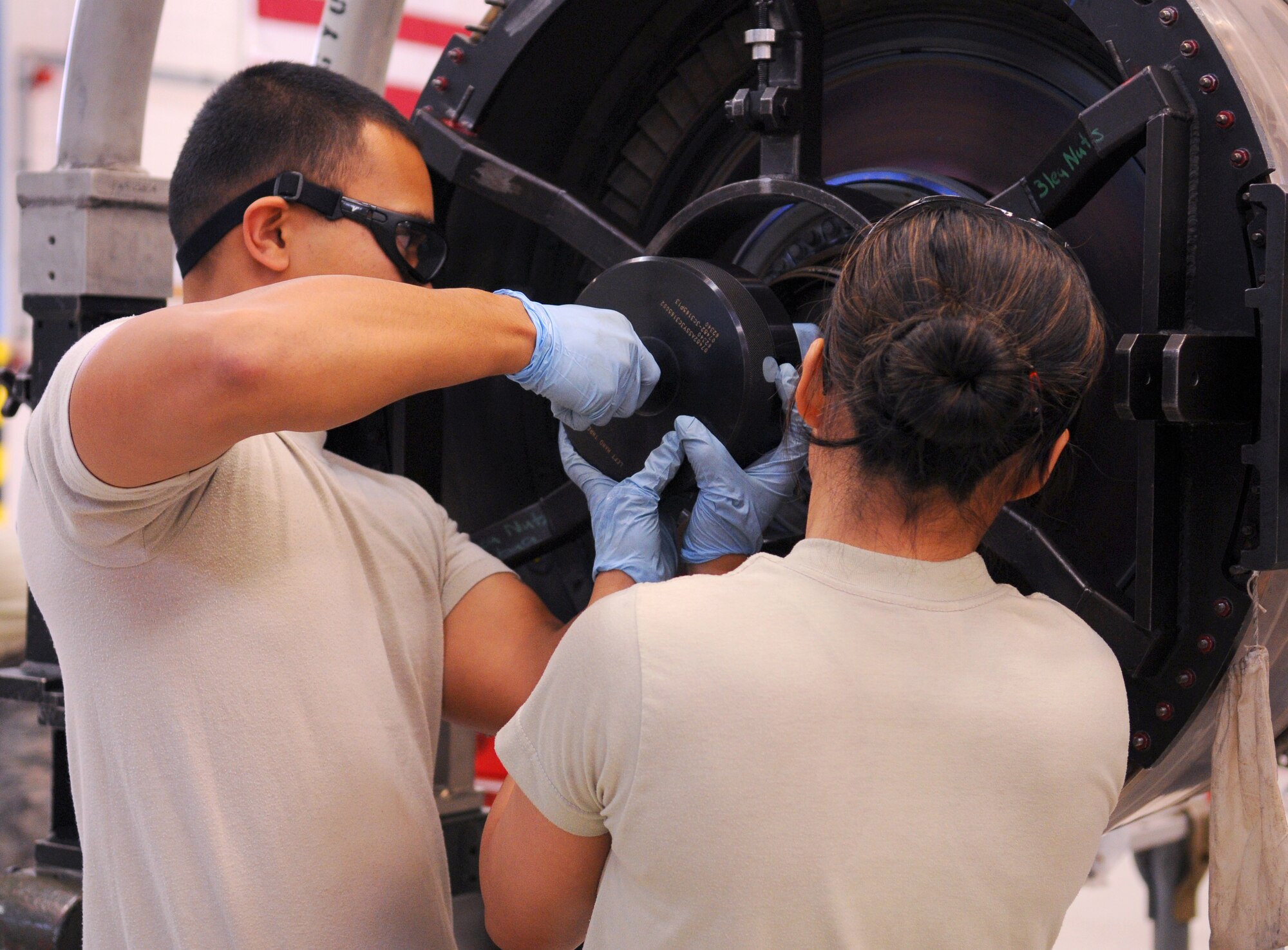 SPANGDAHLEM AIR BASE, Germany -- Senior Airman Timothy Blas and Airman 1st Class Ana Lipatan, 52nd Component Maintenance Squadron aerospace propulsion journeymen, re-assemble an engine after inspecting it for damage at the propulsion flight maintenance shop Sept. 24. Spangdahlem is responsible for repairing damaged engines from Bagram Air Field, Afghanistan, as well as Aviano Air Base, Italy and Joint Base Balad, Iraq. (U.S. Air Force photo/Airman 1st Class Nathanael Callon)