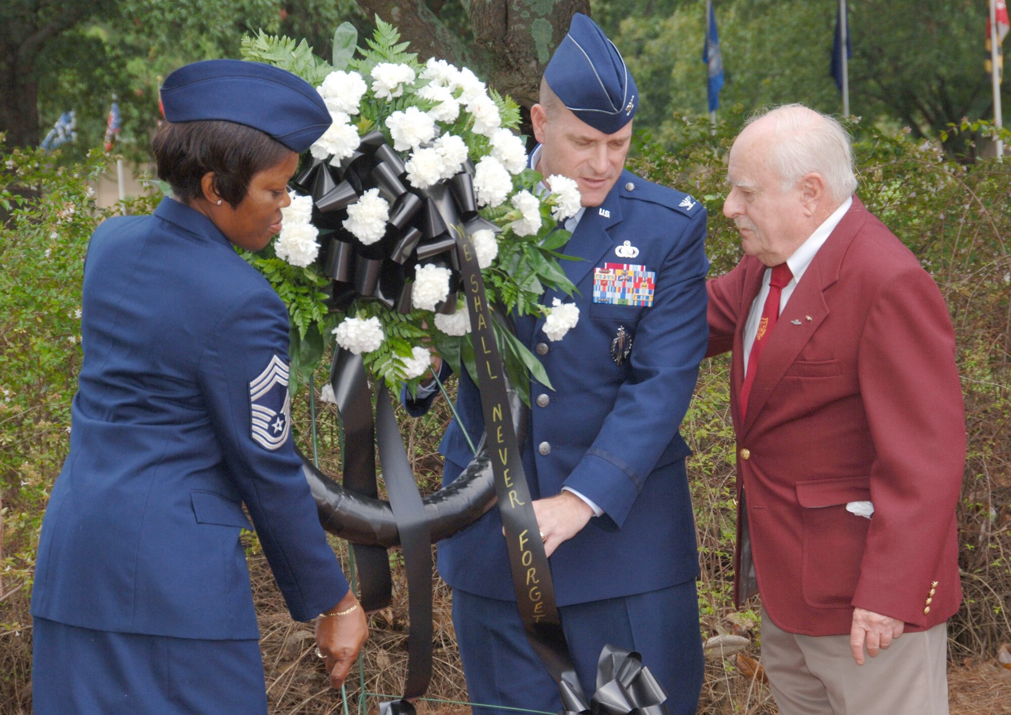 From left, 42nd Force Support Squadron Superintendent Chief Master Sgt. Sheila Knox, 42nd Air Base Wing Commander Col. Kris Beasley and retired Col. Roland Parks place a wreath in front of the POW/MIA monument at Maxwell’s Air Park Sept. 18. (U.S. Air Force photo/Melanie Rodgers Cox) 
