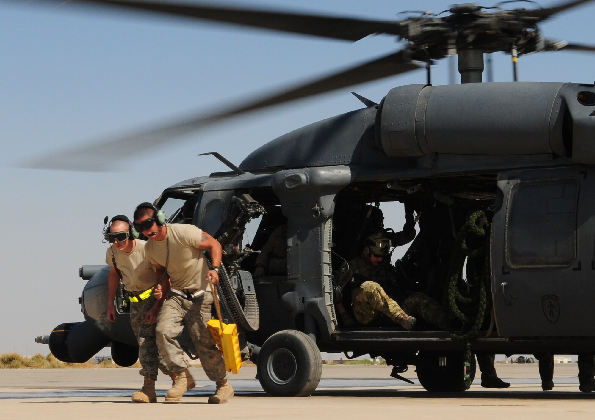 JOINT BASE BALAD, Iraq -- Senior Airmen Justin Story (left) and Michael Morris, both of the 64th Expeditionary Helicopter Maintenance Unit, remove the wheel chocks from an HH-60G Pave Hawk prior to liftoff here Sept. 25, 2009. Both Airmen are deployed from Moody Air Force Base, Ga.  (U.S. Air Force photo/Staff Sgt. Heather M. Norris)