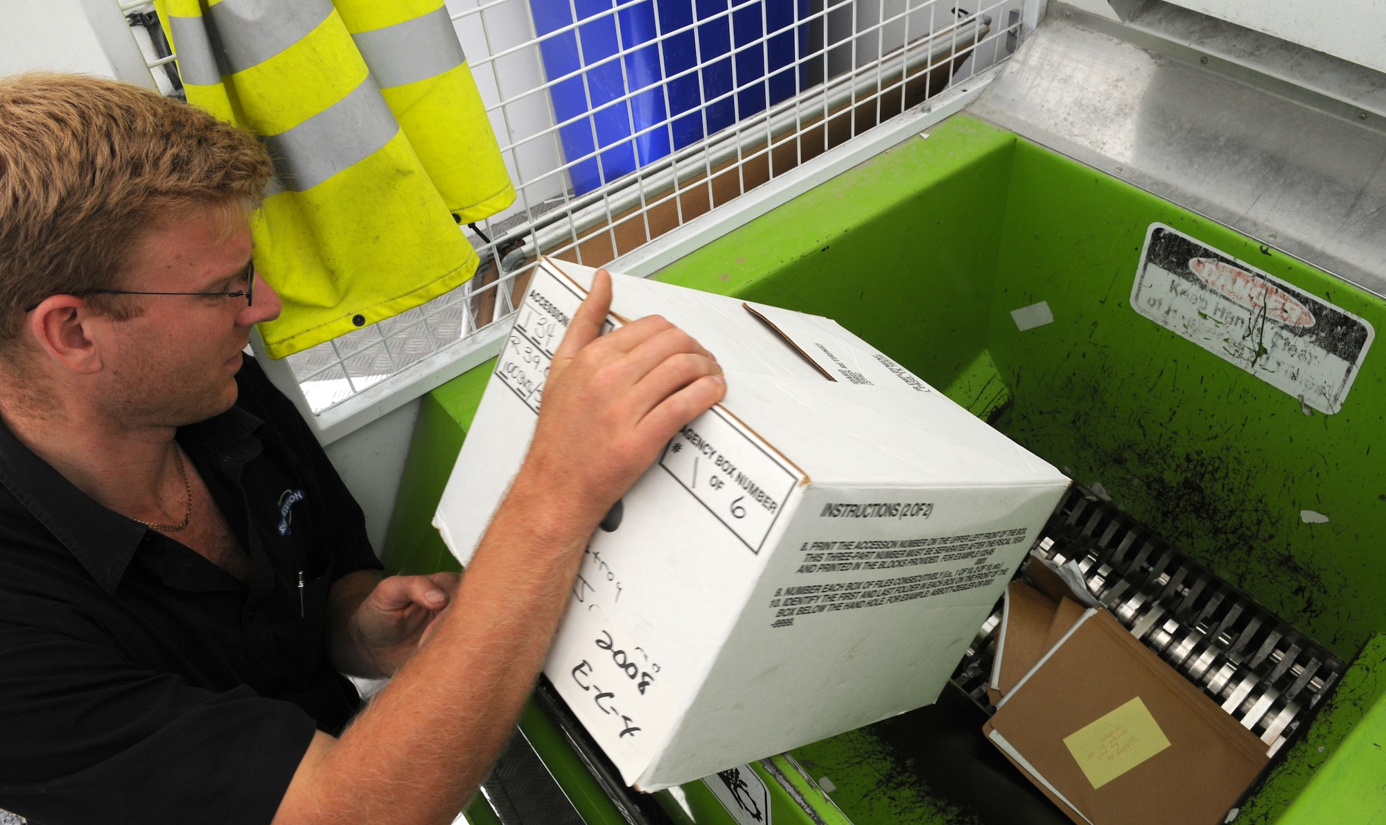 RAF MILDENHALL, England – Marc Athins, throws a box of paper into a mobile shredding truck Sept. 25. The contractors shredded more than 26,000 pounds of paper for recycling throughout the day. (U.S. Air Force photo/ Staff Sgt. Jerry Fleshman)