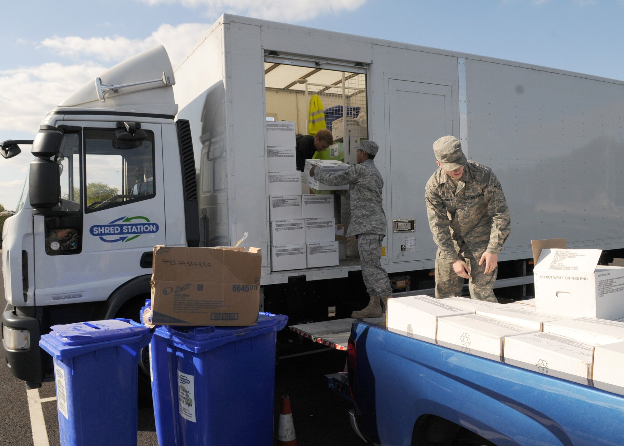 RAF MILDENHALL, England – Airman Russell Swinney and Airman 1st Class Leroy Jackson, 100th Communication Squadron, deliver boxes of paper to a mobile shredding truck Sept. 25. The contractors shredded more than 26,000 pounds of paper for recycling throughout the day. (U.S. Air Force photo/ Staff Sgt. Jerry Fleshman)