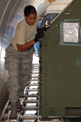 Airman 1st Class Karen Gullingsrud, 8th Logistics Readiness Squadron, positions cargo inside a chartered aircraft for transport to exercises Distant Frontier and Red Flag-Alaska. These exercises provide an operations training environment for aircrews, maintenance crews, command and control elements and intelligence experts. (U.S. Air Force photo/Master Sgt. Anna Hayman)
