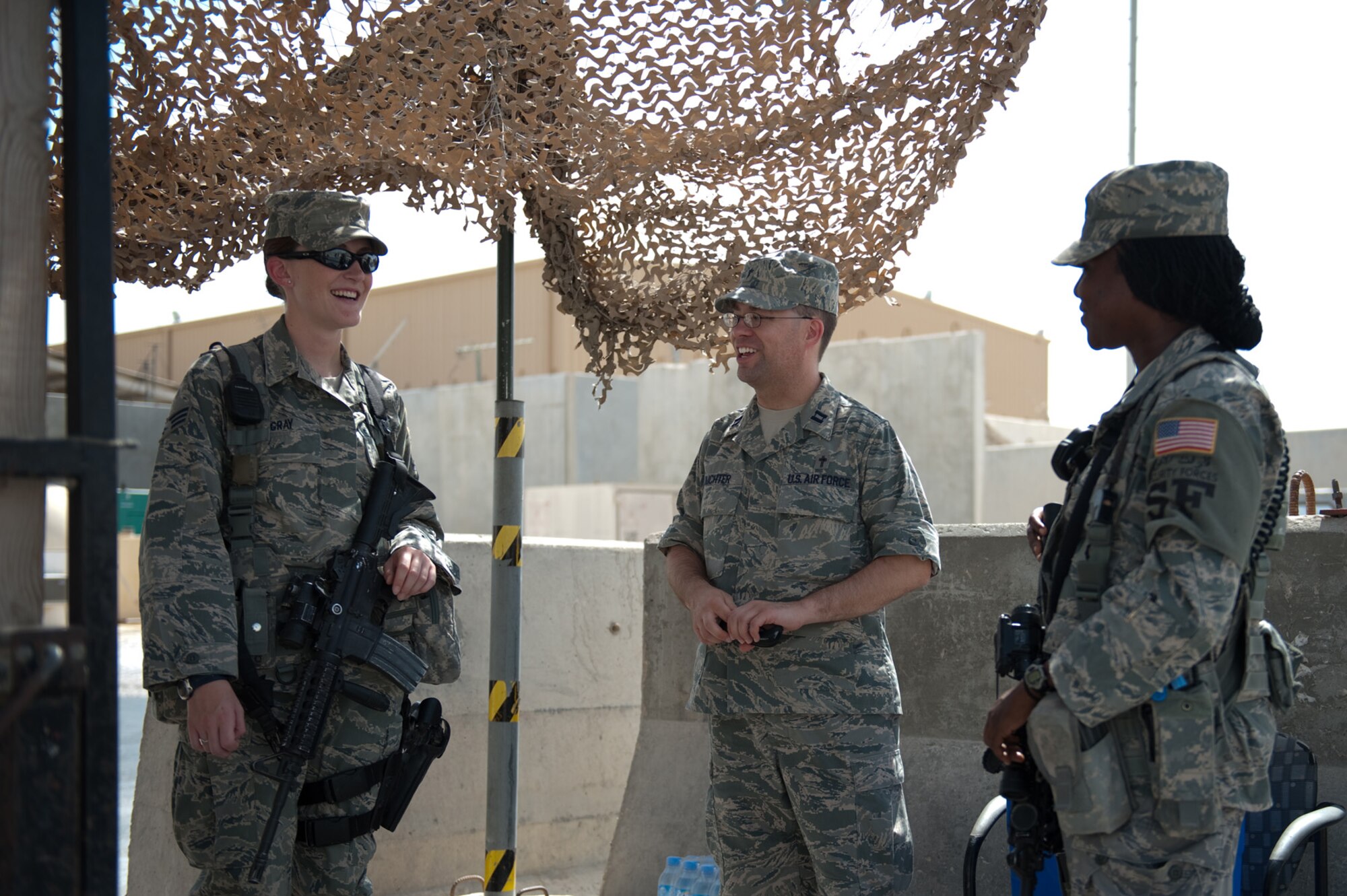 Chaplain (Capt.) Mark Juchter, 379th Air Expeditionary Wing, visits with Senior Airman Danielle Gray and Staff Sgt. Renisha Smith, 379th Expeditionary Security Forces Squadron, Sept. 24, in Southwest Asia. Chaplain Juchter leads the weekly traditional Protestant service and visits regularly with Airmen around the base. Chaplain Juchter is deployed from Tinker Air Force Base, Okla., to minister for servicemembers deployed in support of Operations Iraqi and Enduring Freedom. (U.S. Air Force photo/Staff Sgt. Robert Barney) 