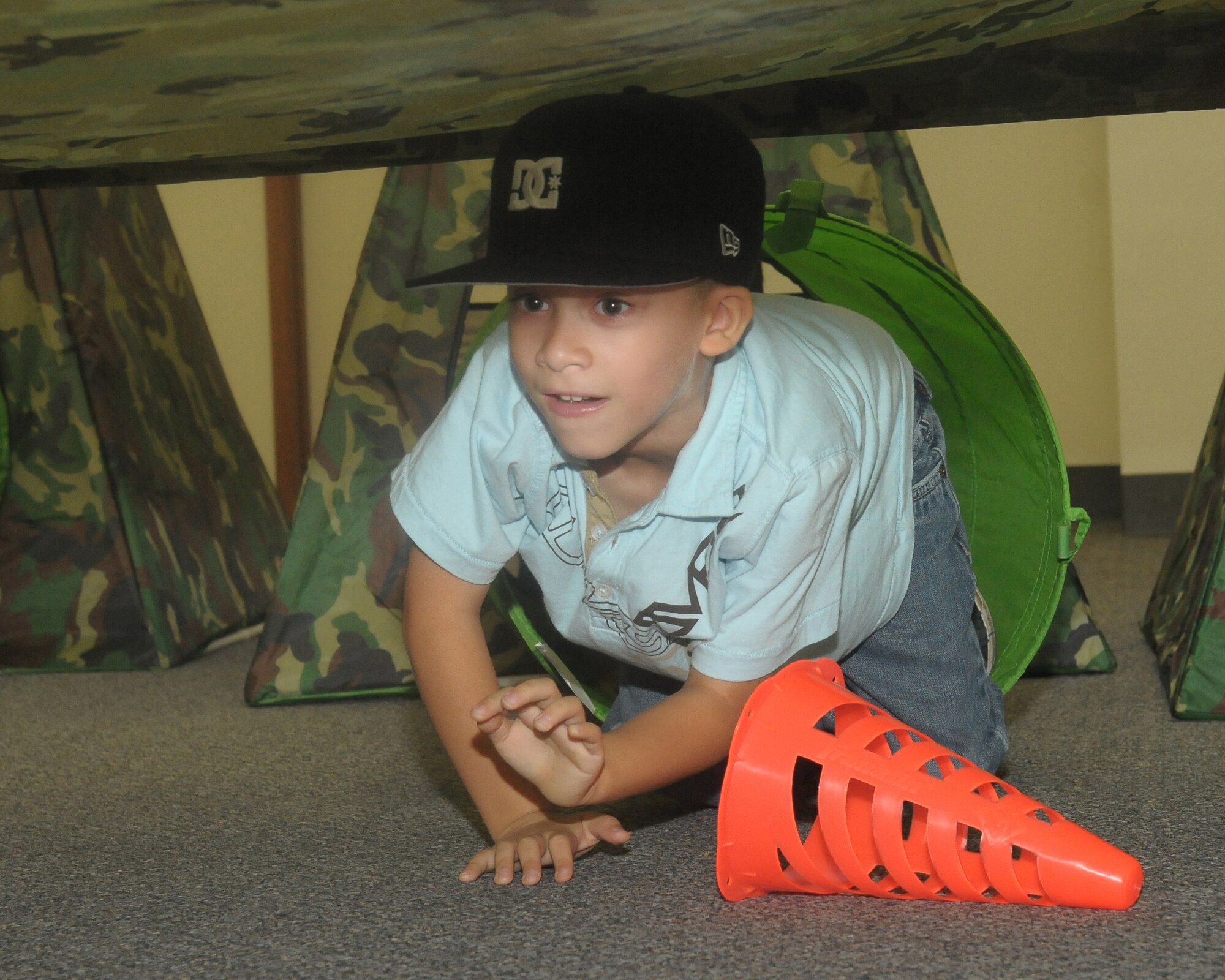 YOKOTA AIR BASE, Japan -- Kangel Rivera, son of Staff Sgt. Luis Rivera, 374th Aircraft Maintenance Squadron, low crawls through an obstacle course Sept. 26 during the base's Kids Understanding Deployment Operation Support event at Bldg. 400. K.U.D.O.S. is an annual event to help children better understand their parents' deployment by going through part of the process themselves. More than 275 children attended this year's event. (U.S. Air Force photo/Airman 1st Class Sean Martin)