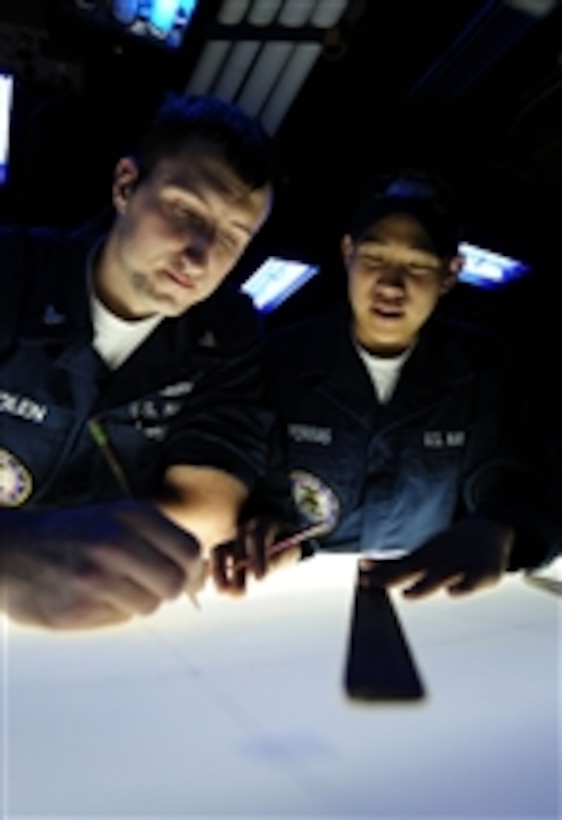 U.S. Navy Petty Officer 2nd Class Daniel Bolen and Seaman Jettrick Porras practice plotting enemy contacts while standing watch in the combat direction center aboard the aircraft carrier USS John C. Stennis (CVN 74) in the Pacific Ocean on Sept. 22, 2009.  The Stennis is underway conducting fleet replacement squadron carrier qualifications off the coast of southern California.  