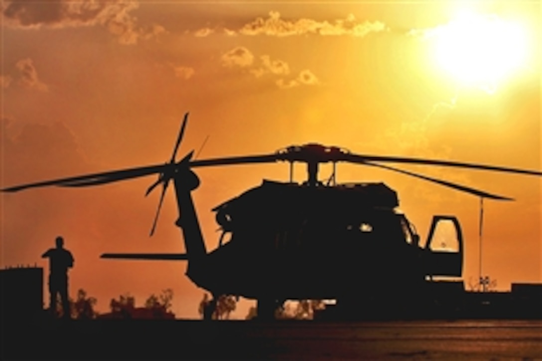 Under the morning sun, a UH-60 Black Hawk helicopter crew chief starts to remove the fly away gear from a helicopter during a preflight inspection on Camp Taji, Iraq, Sept. 24, 2009. The Black Hawk crew is assigned to the 1st Cavalry Division's, 3rd Battalion, 227th Aviation Regiment, 1st Air Cavalry Brigade.