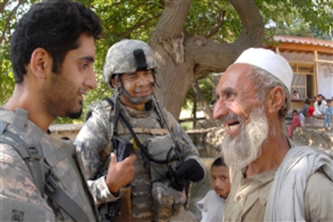 A U.S. soldier stops to speak with Salie Salam Muhammad,right, with help from an interpreter, left, in Yargul, Afghanistan, Sept. 26, 2009, during a dismounted patrol in the village to help determine the overall feeling of town members towards the presence of coalition forces and to assess the general basic needs of local residents.