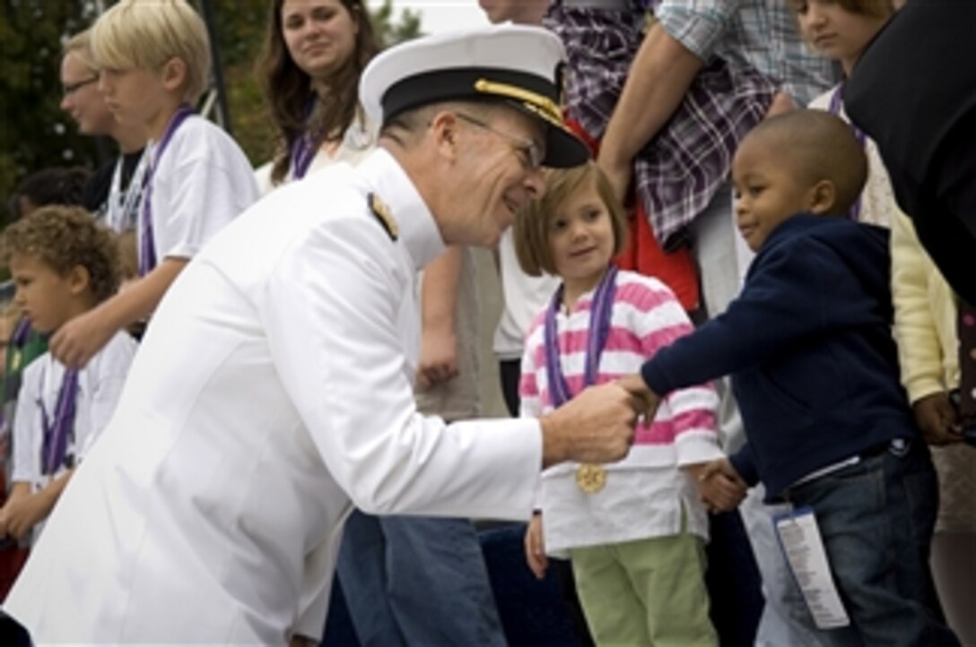Chairman of the Joint Chiefs of Staff Adm. Mike G. Mullen greets the children of fallen heroes at the Fourth Annual Time of Remembrance ceremony honoring America's fallen heroes in Afghanistan and Iraq on the West Lawn of the U.S. Capitol on Sept. 26, 2009.  