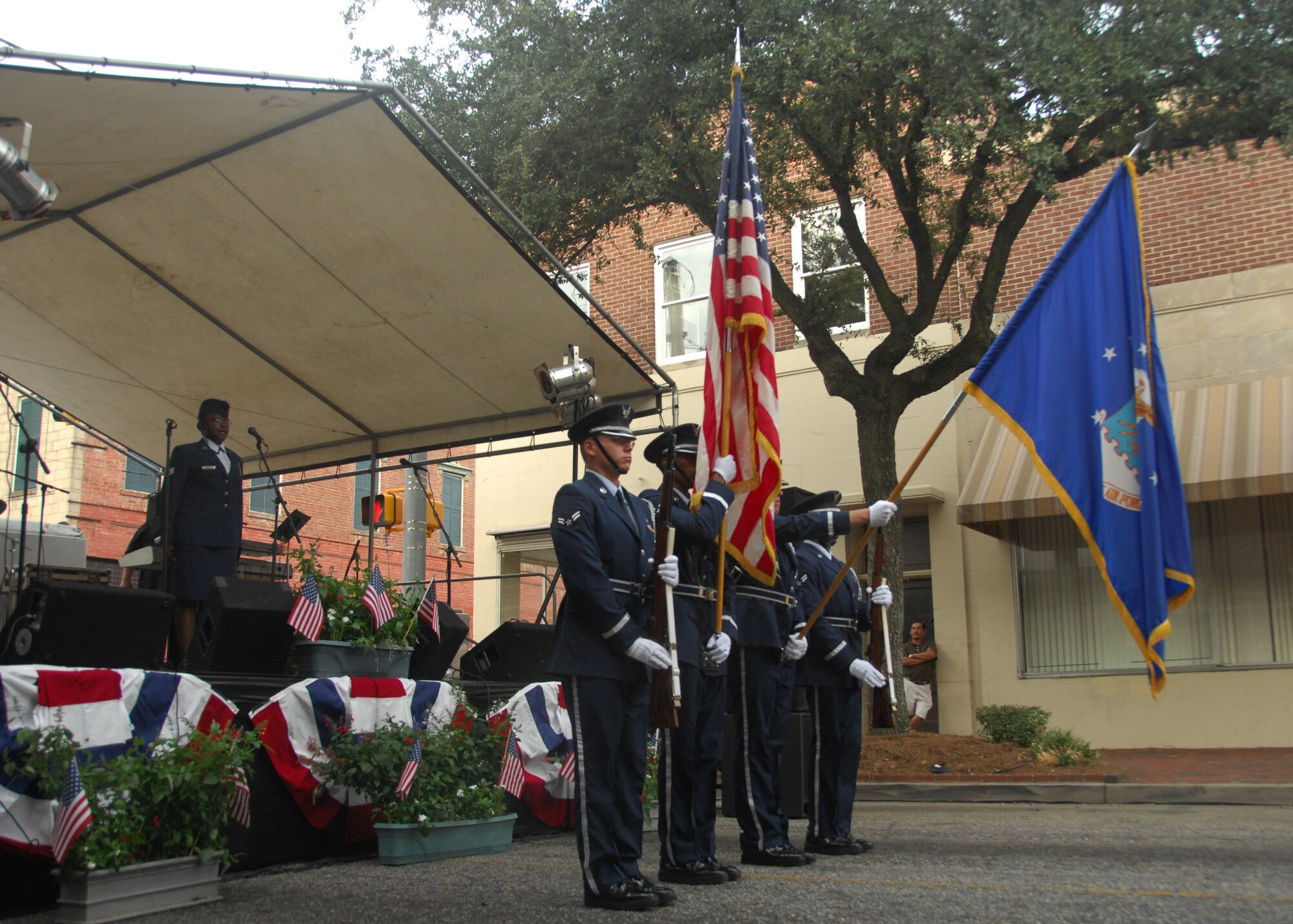 SHAW AIR FORCE BASE, S.C. -- The Shaw Air Force Base Honor Guard presents the colors as Staff Sgt. Regina Kelly, 20th Force Support Squadron, sings the National Anthem at the Sumter-Shaw Streetfest Sept. 25. The streetfest brought the Shaw and Sumter communities together for an evening of food, music and fun. (U.S. Air Force photo/2nd Lt. Emily Chilson)