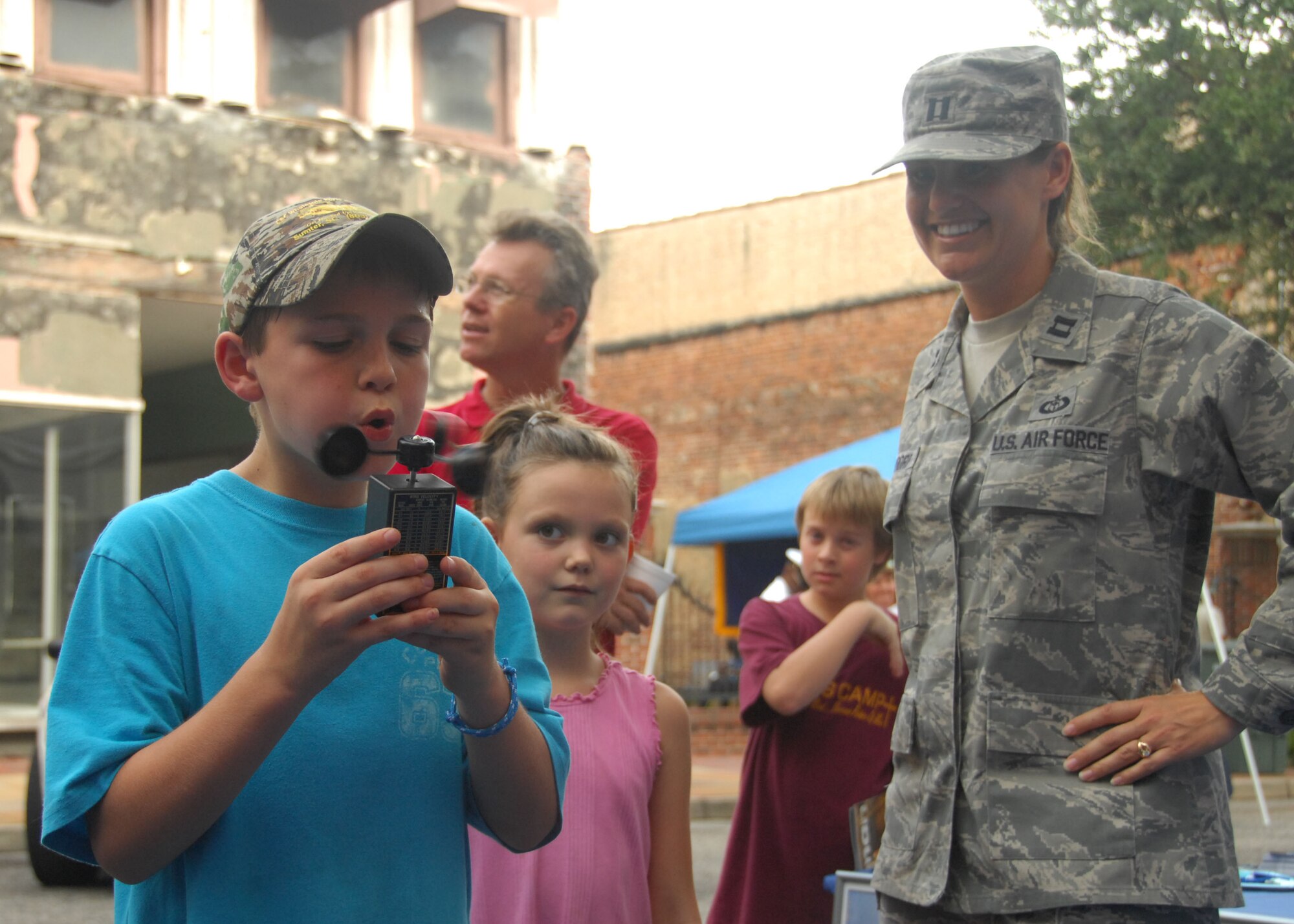 SHAW AIR FORCE BASE, S.C. -- Kenneth Jordan, 8, learns how to measure wind speed by blowing into an anemeter at the 28th Operational Weather Squadron display while his cousin Abby Player, 6, and Capt. Tiffany Bendorf watch. The 28th OWS display was part of the Sumter-Shaw Streetfest Sept. 25. (U.S. Air Force photo/2nd Lt. Emily Chilson)