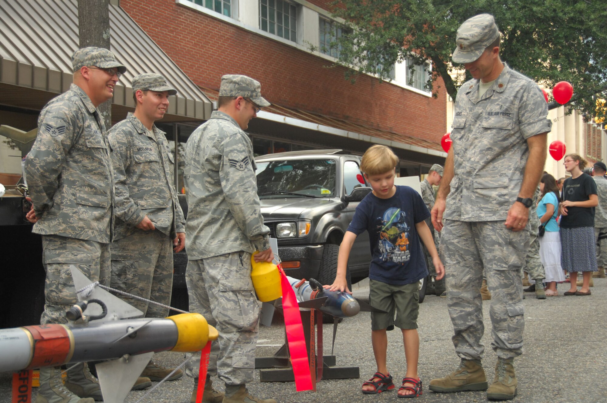 SHAW AIR FORCE BASE, S.C. -- Major Brian Hughes (right), 20th Aerospace Medical Squadron bioenvironmental flight, and his son Reagan Hughes, 7, look at the 20th Maintenance Group display at the Sumter-Shaw Streetfest Sept. 25. The 20th MXG is one of several units from Shaw who participated in the streetfest.  (U.S. Air Force photo/2nd Lt. Emily Chilson)