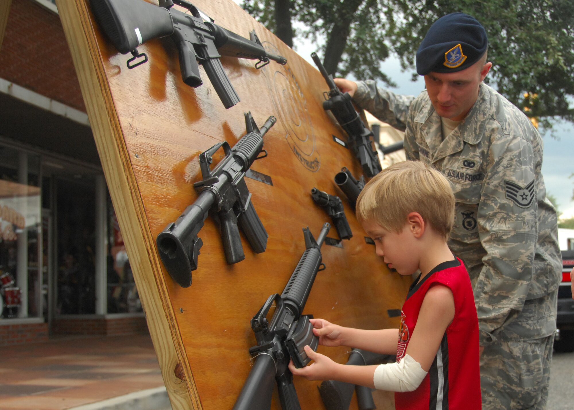 SHAW AIR FORCE BASE, S.C. -- Staff Sgt. Ross Richwine, 20th Security Forces Squadron, tells Luke Altum, 4, about the different weapons on display. Luke was visiting the Sumter-Shaw Streetfest with his mom and dad Sept. 25. (U.S. Air Force photo/2nd Lt. Emily Chilson)