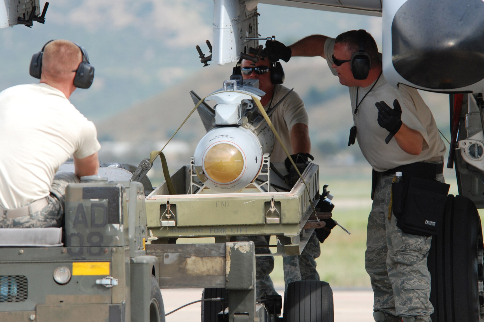 Senior Airman Cody Burt and Technical Sgts. Jason Hairgrove and Darren Kuhlmann, weapons loaders with the 717th Aircraft Maintenance Squadron, from Barksdale Air Force Base, La., upload an AGM-65 Maverick missile on a 47th Fighter Squadron A-10 Thunderbolt II aircraft in support of Patriot Rifle III, Hill Air Force Base, Utah, on September 10, 2009. More than 54 members of the 917th Wing from Barksdale and six aircraft participated in the exercise. (U.S. Air Force photo/Master Sgt. Greg Steele) 
