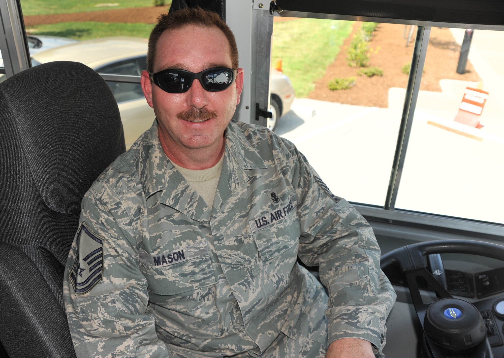 Master Sgt. Chris Mason stands by at the wheel of an Air Force bus during a visit.  He takes care of visitors during many special activities and events and is always ready to help.  (U.S. Air Force photo/Tech Sgt. Dan Oliver)