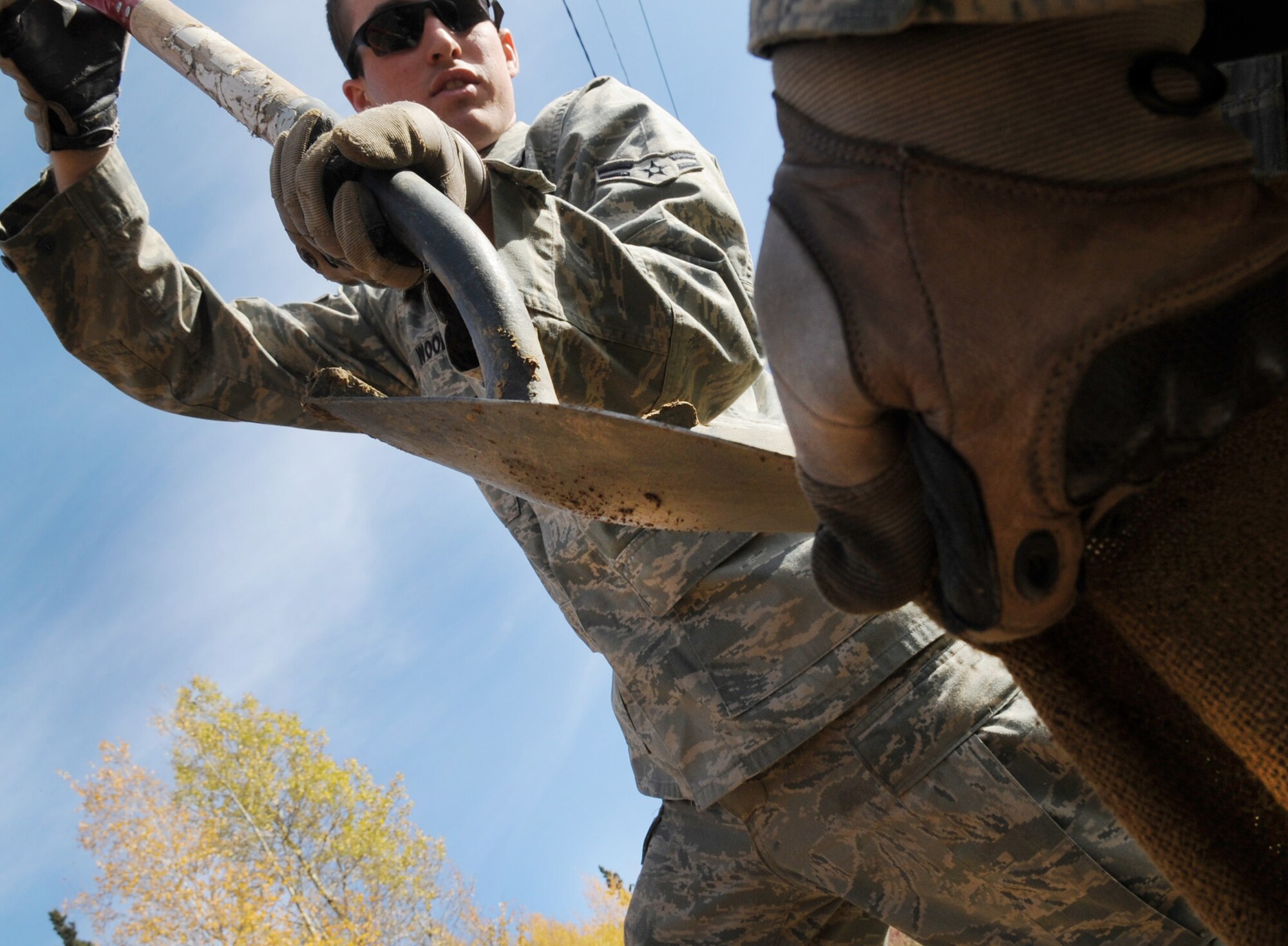 Airman 1st Class Brandon Wood shovels dirt into a sand bag Sept. 24, 2009, Eielson Air Force Base, Alaska.  The sand bags will be placed over explosives to reduce blast and flying debris. The old ski lift is being removed to make way for a new lift. Airman Wood is assigned to the 354th Civil Engineer Squadron Explosive Ordinance Disposal Flight. (U.S. Air Force photo/Airman 1st Class Laura Goodgame)