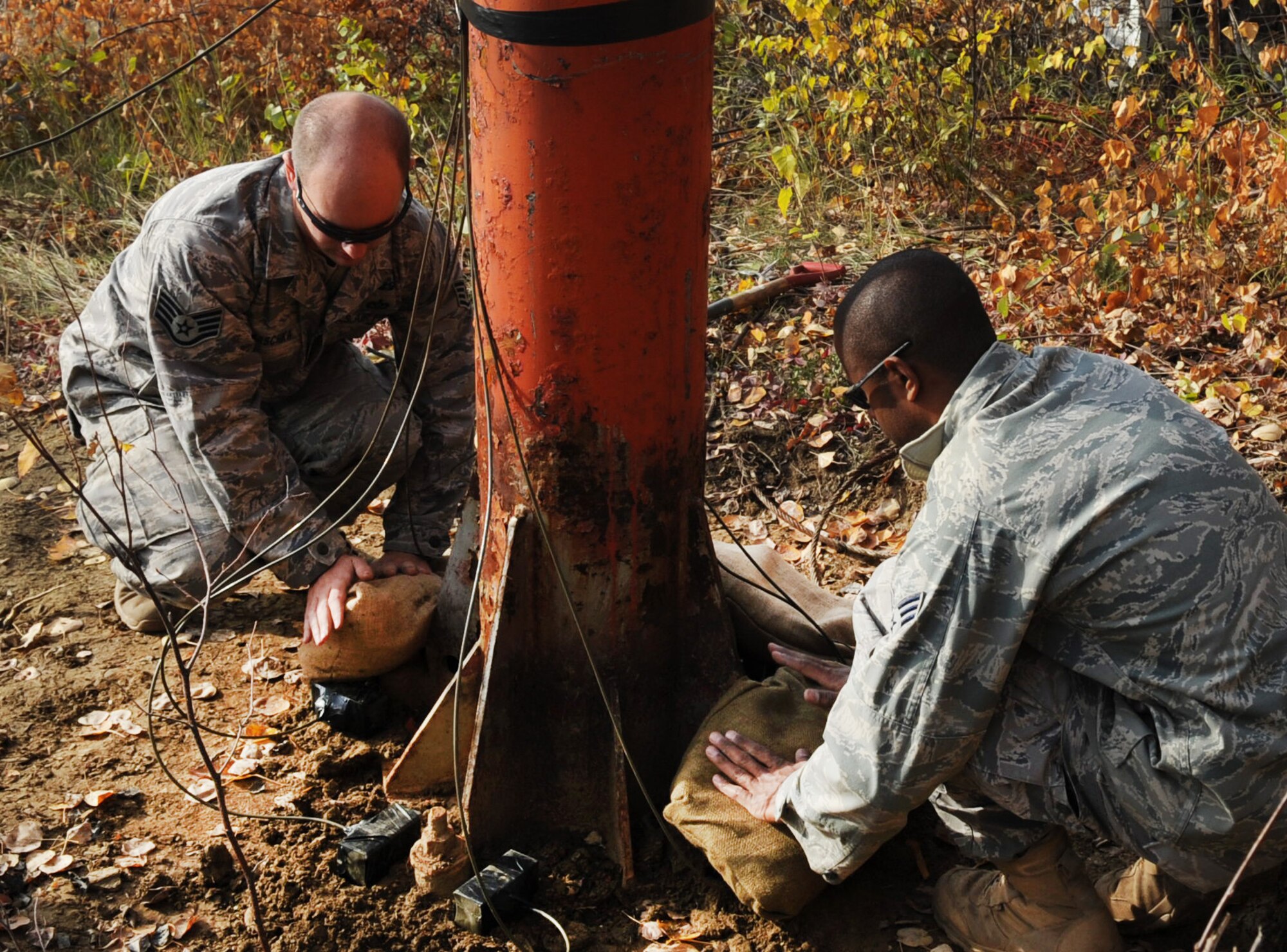 Staff Sgt. Mark Maschka and Senior Airman Dave Thomas carefully place sand bags over explosives to absorb some of the blast Sept. 24, 2009, Eielson Air Force Base, Alaska.  Sergeant Maschka and Airman Thomas are assigned to the 354th Civil Engineer Squadron Explosive Ordinance Disposal Flight. (U.S. Air Force photo/Airman 1st Class Laura Goodgame)
