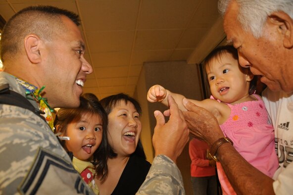 Air Force Reserve Master Sgt. Mark Hatori reunites at last with wife Cindy, daughters Kiana and Kauanoe and father-in-law Kenneth Amimoto. Sergeant Hatori and six of his fellow aerial porters from the 624th Regional Support Group, Hickam Air Force Base, Hawaii, arrived at Honolulu airport Sept. 28 following a four-month deployment to Joint Base Balad. They were the last group to return of a 25 member team which deployed in support of Operation Iraqi Freedom to the 332nd Expeditionary Logistics Readiness Squadron. While there they handled baggage pallets, general cargo, special handling cargo, rolling stock and aerospace ground equipment. (Air Force photo by Master Sgt. Daniel Nathaniel)